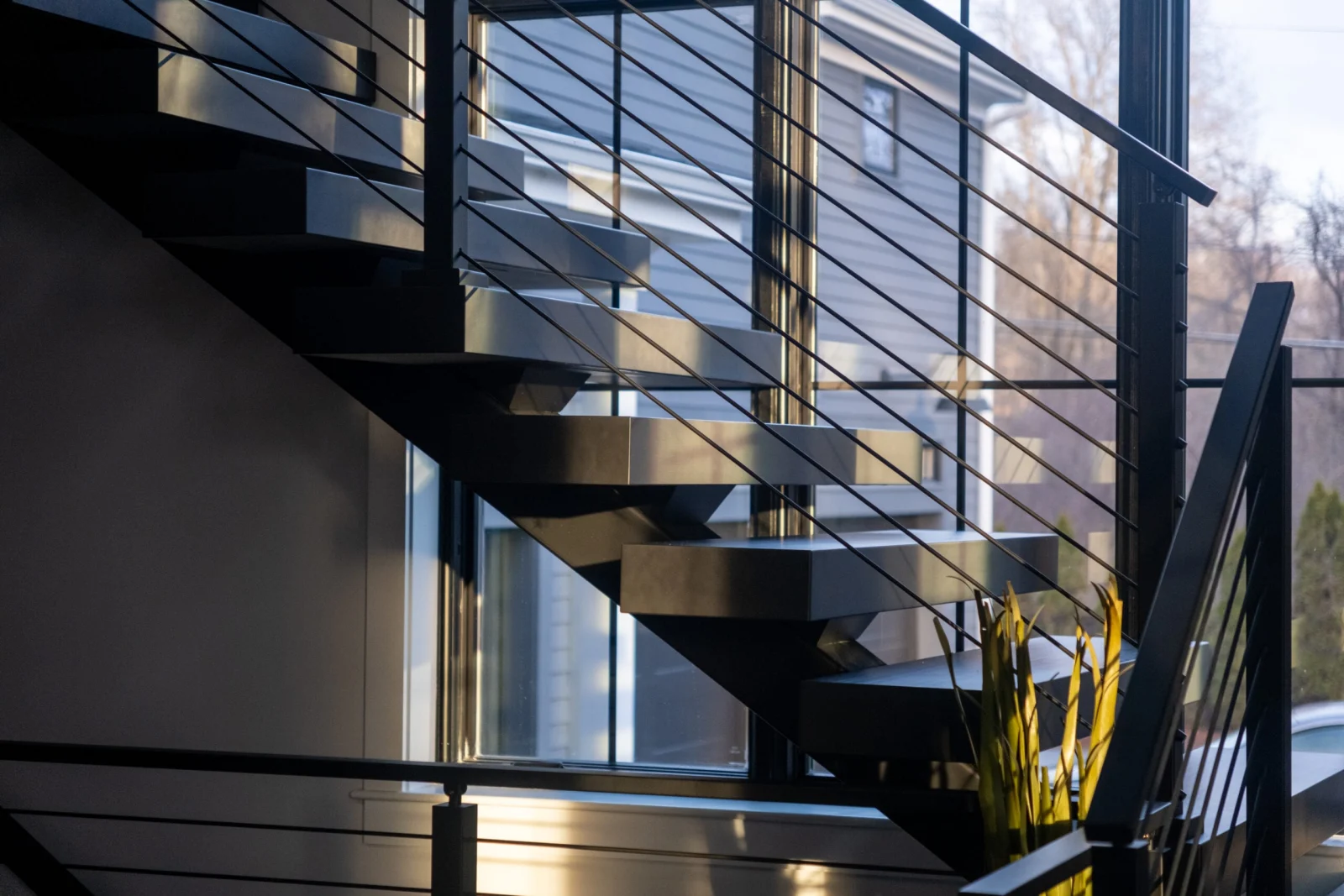 Backlit profile of the stair and rod railing against evening windows