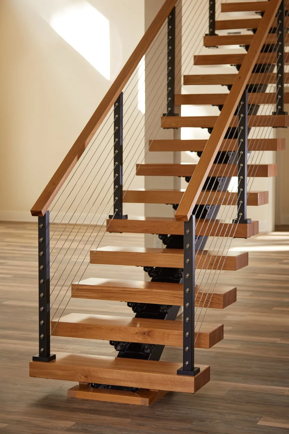 Open stair with wood treads and cable infill seen straight on from below