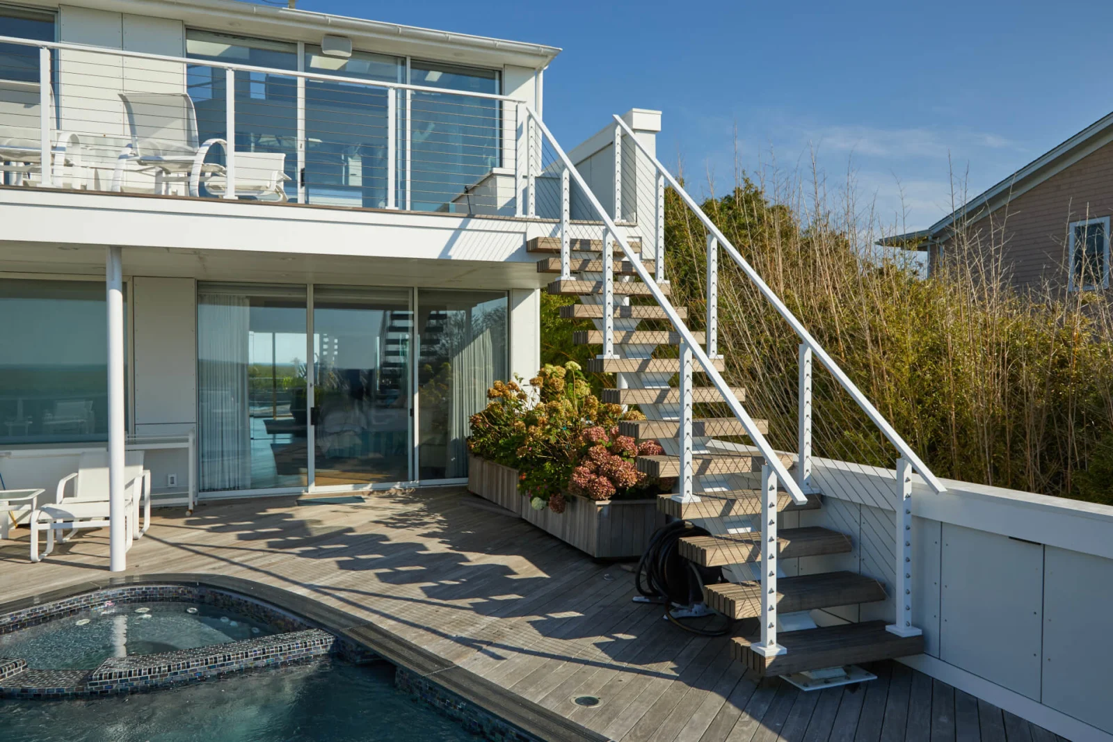 Pool deck view of the stair linking two levels of a beachfront house