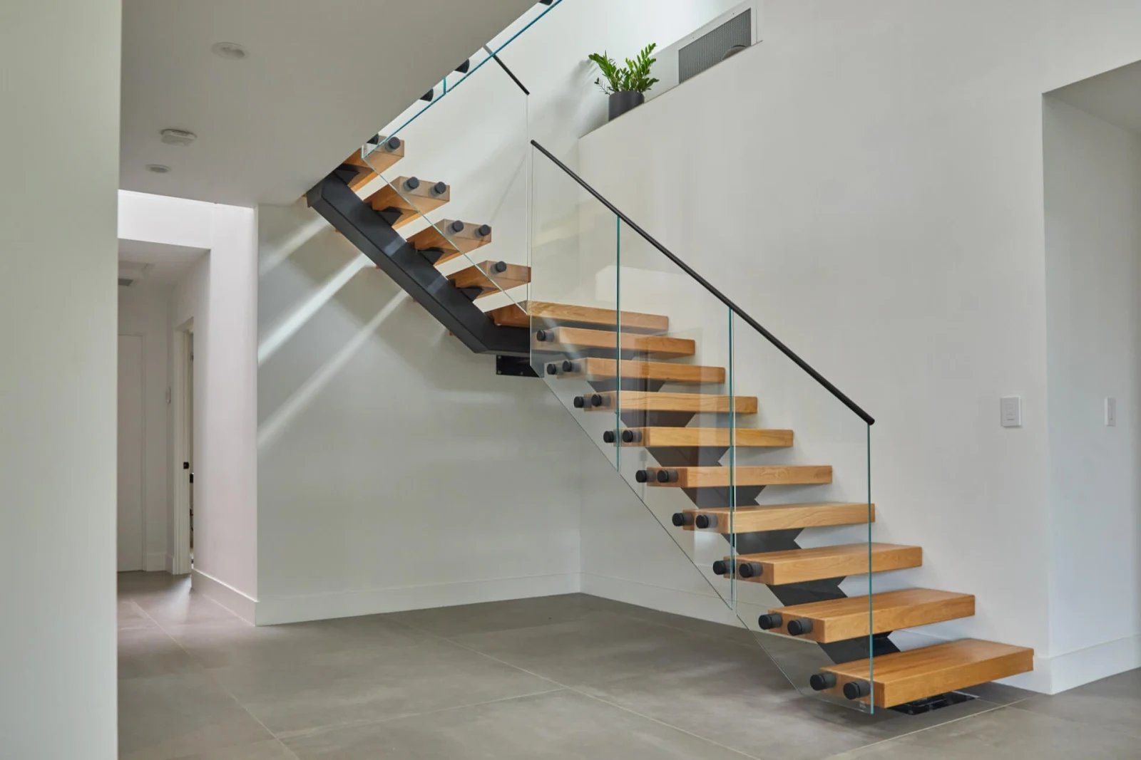 Flight seen in profile above a polished concrete floor with glass railing