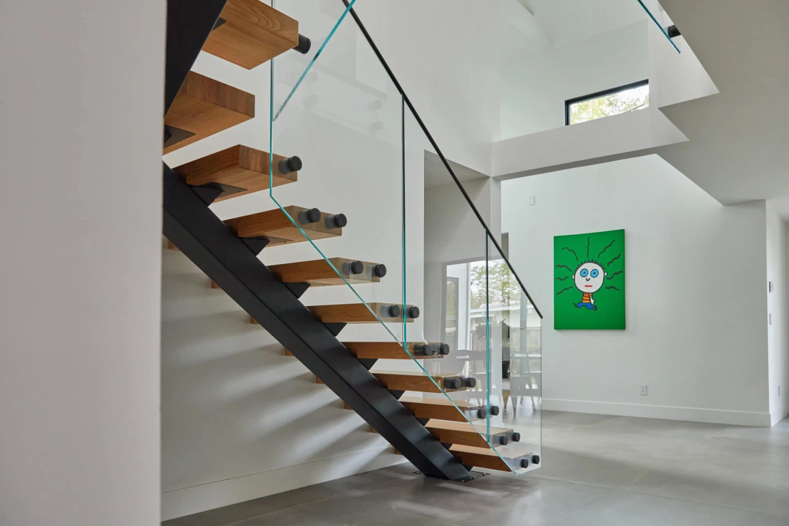 Open riser stair on a black center stringer in a bright white room