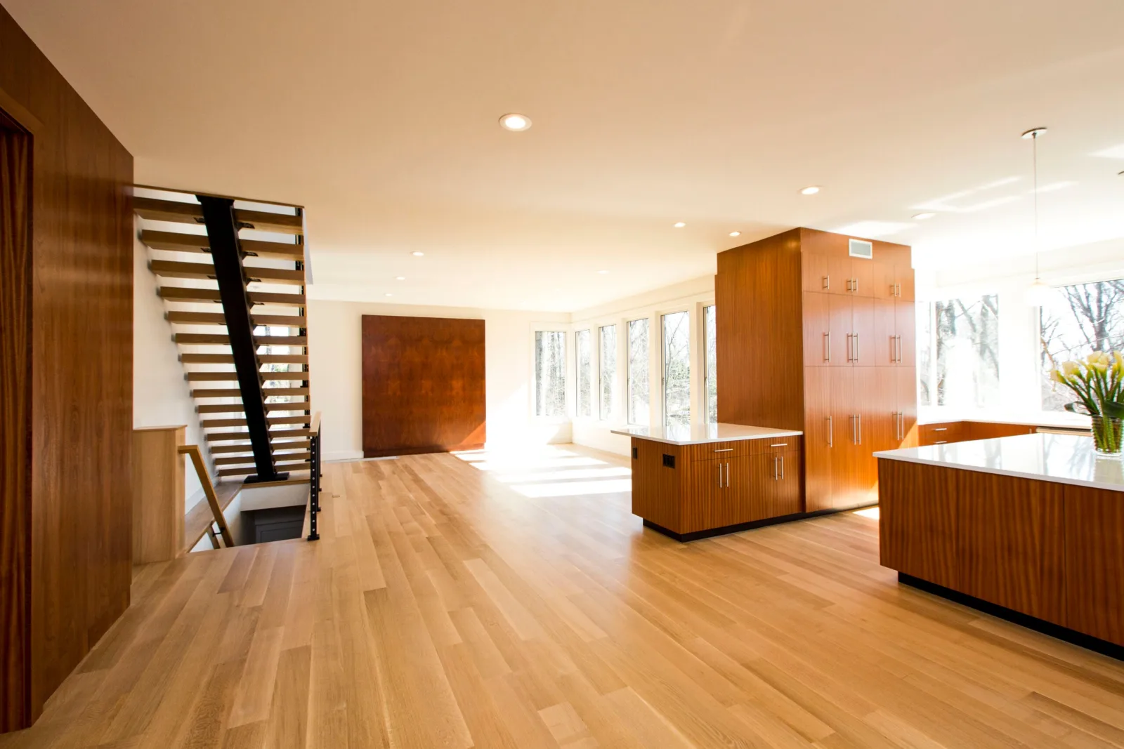 Open floor plan with wood cabinetry and the stair tucked along the left wall