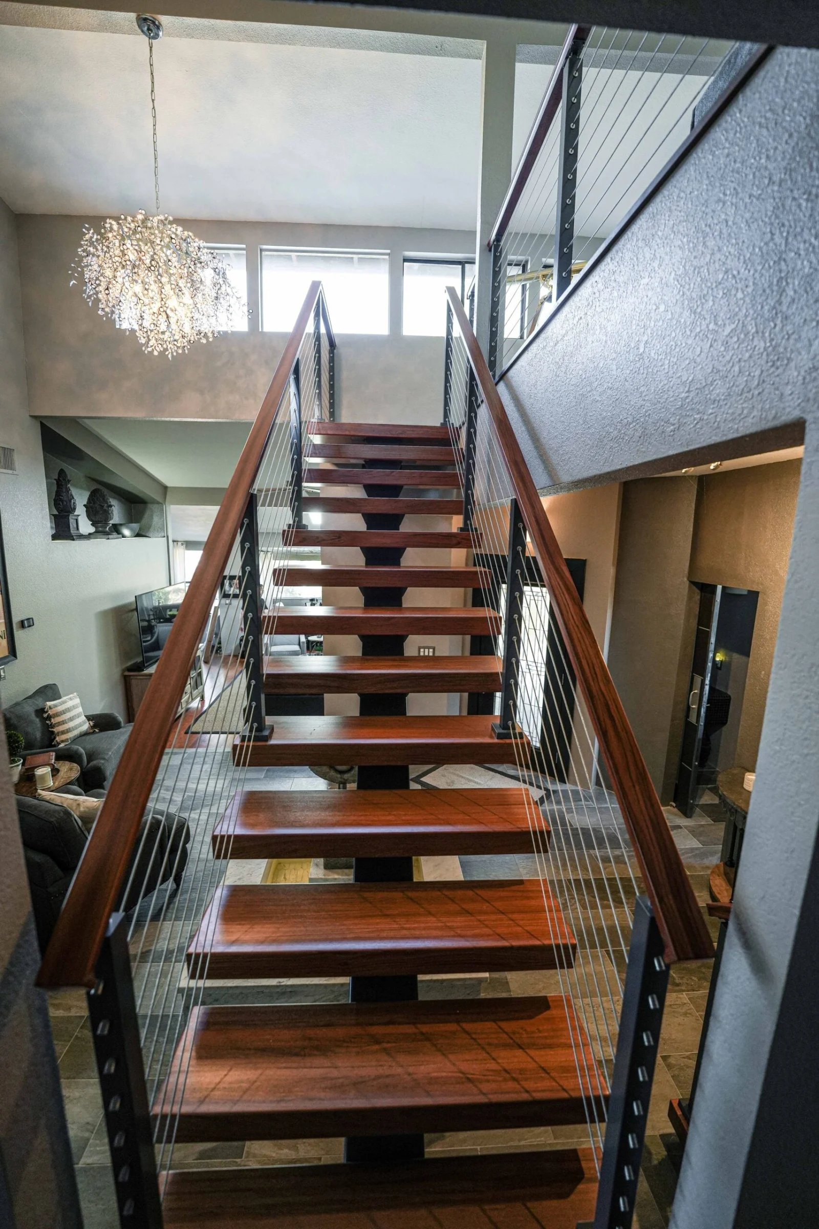 Looking up the flight toward a loft with a branching light fixture above