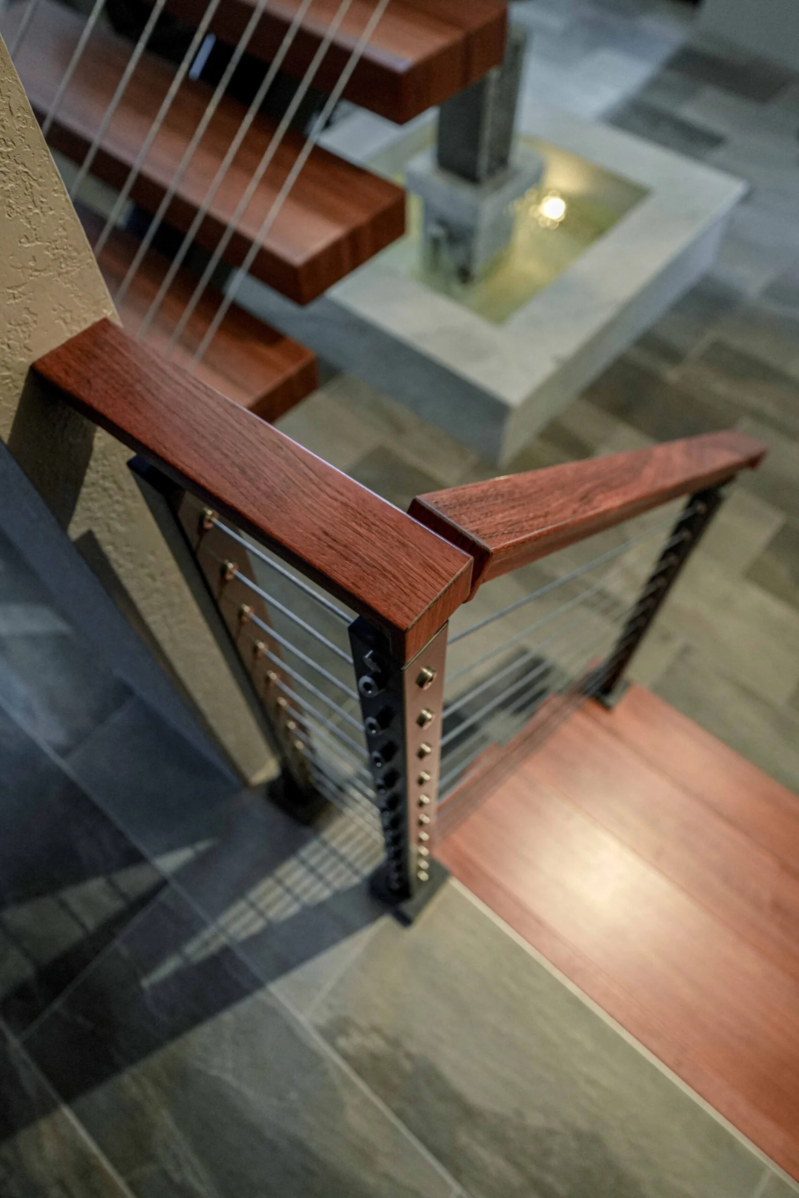 Looking down where the wood-capped railing turns at the bottom tread