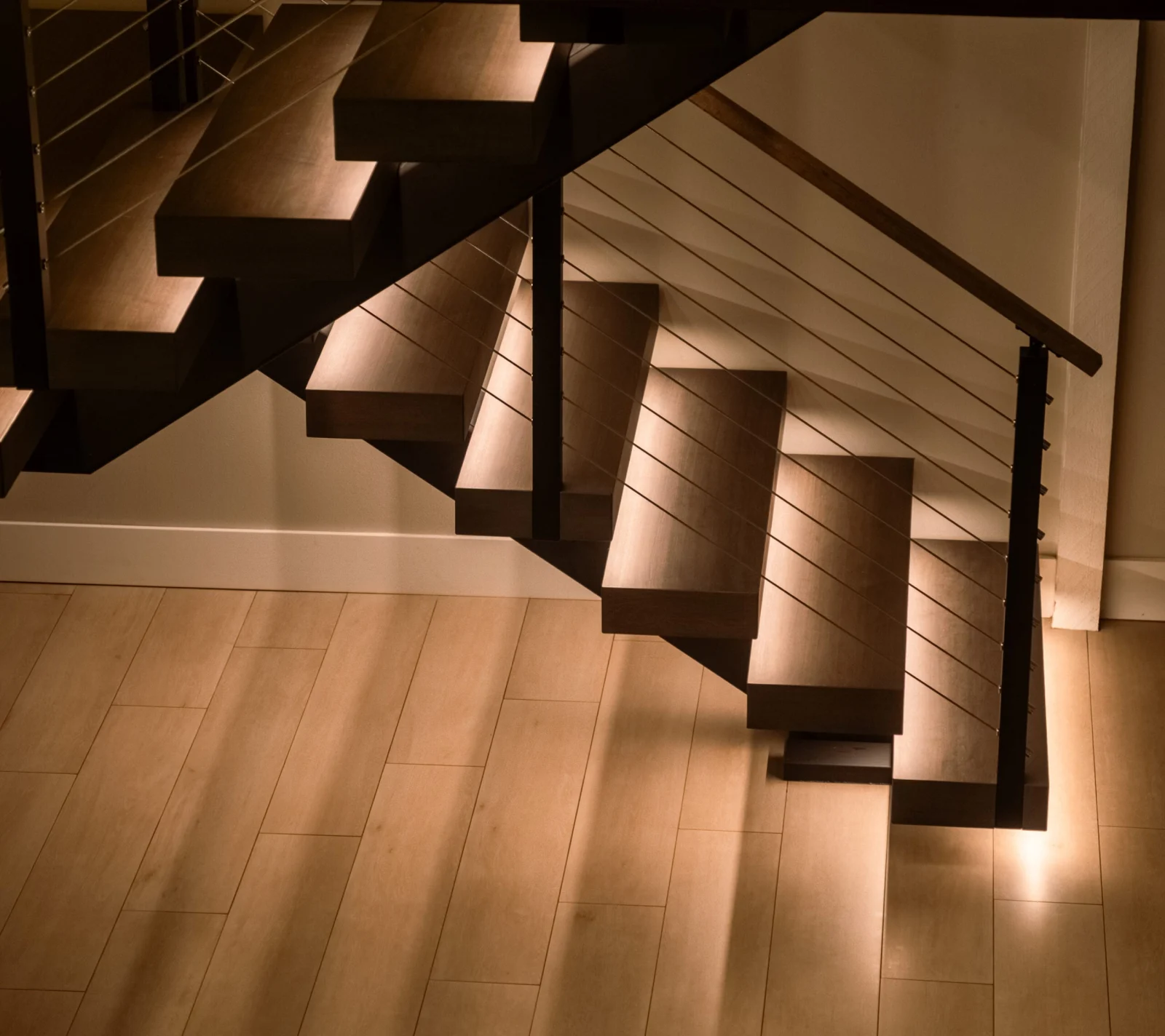 Cable railing and cantilevered treads seen from the floor below the landing
