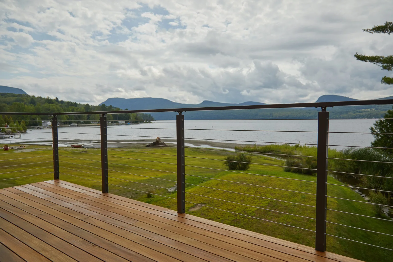 Cable railing framing an open view across water to distant mountains