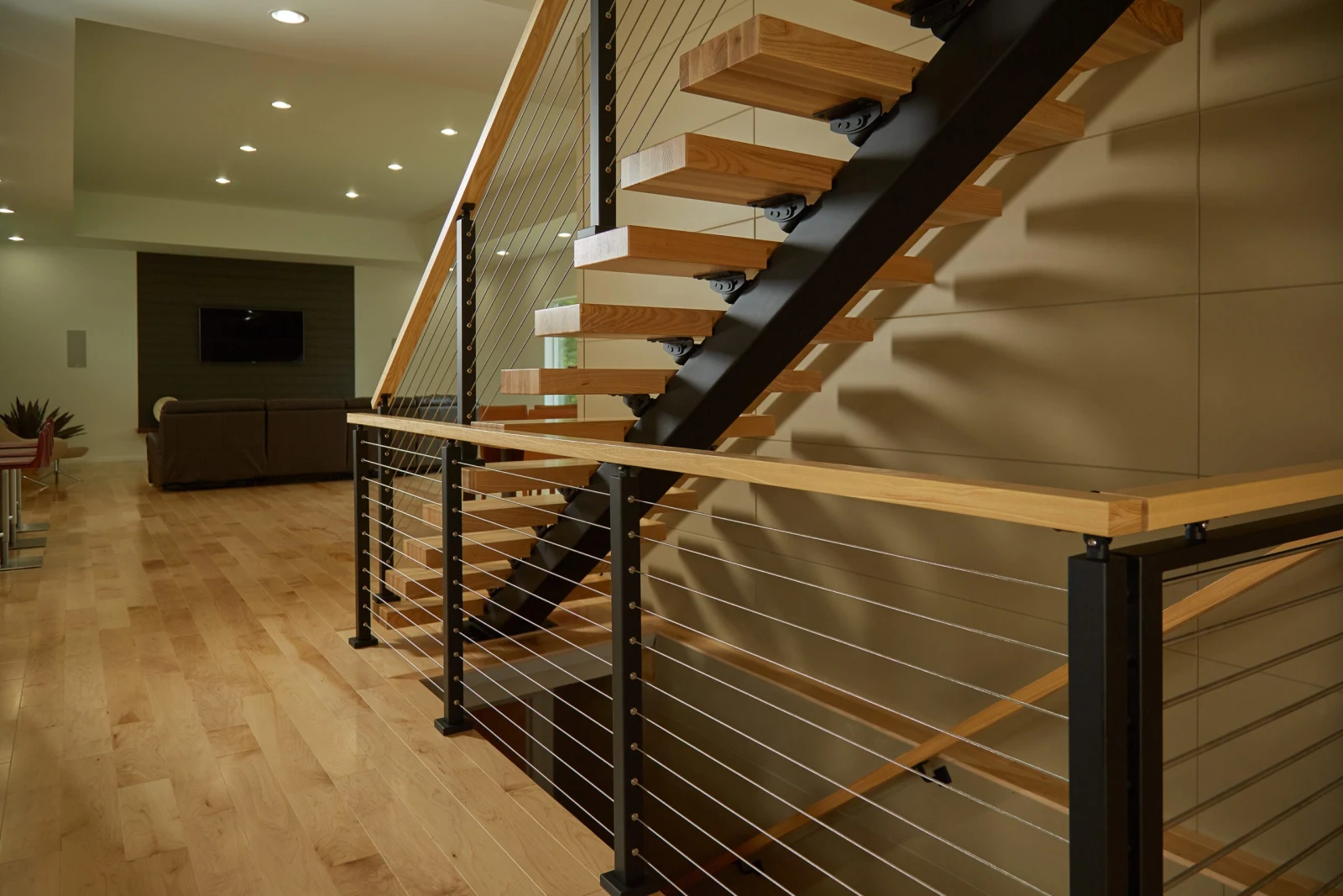 Cable railing along a lower level with the stair rising behind it