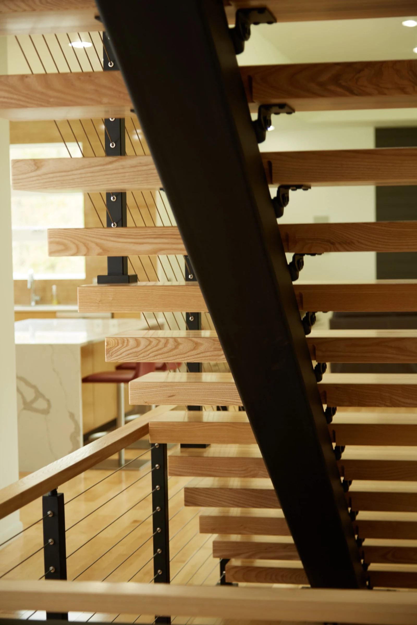Looking up through open risers at the black stringer and tread undersides
