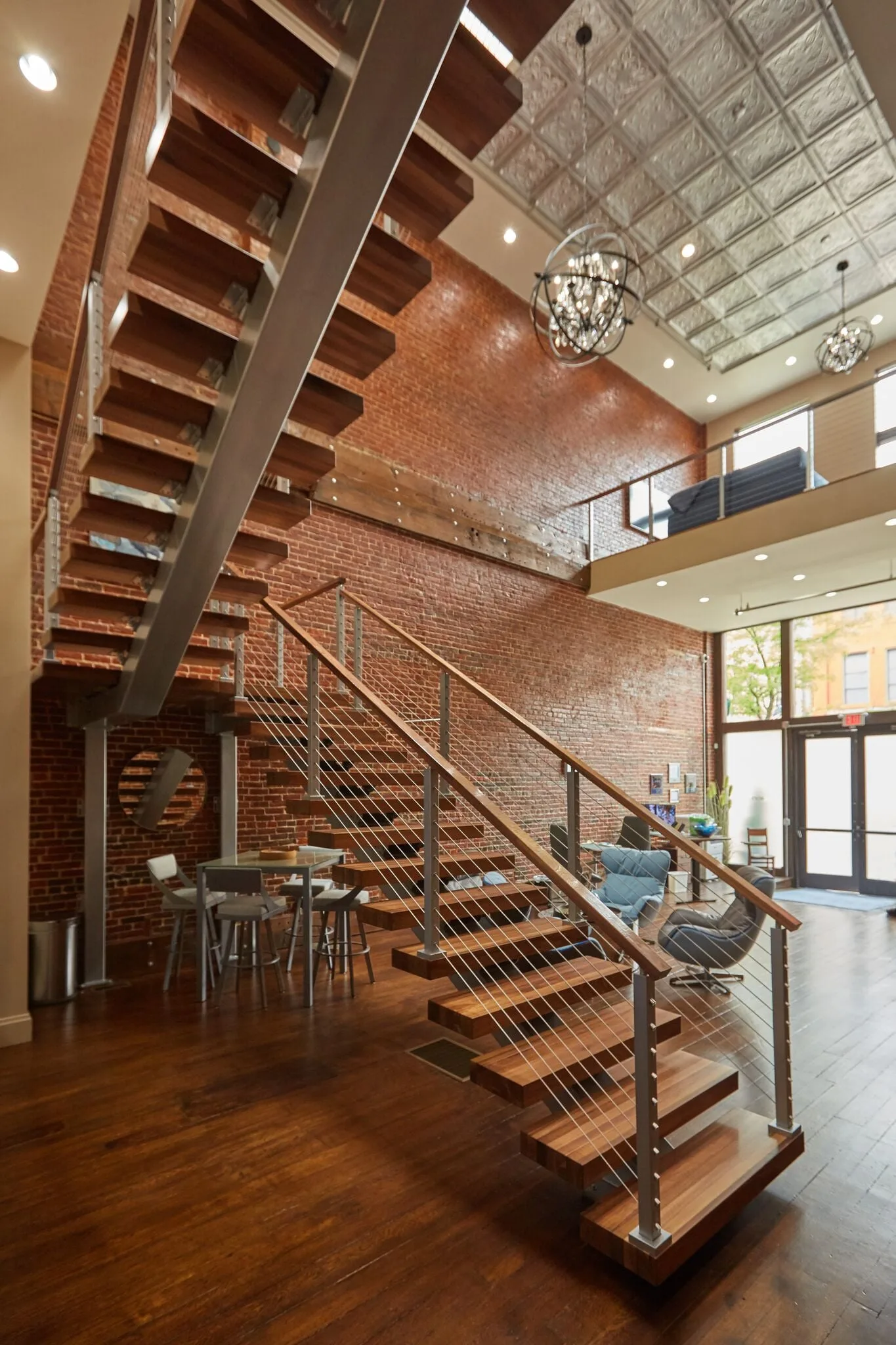 Two flights crossing a brick-lined atrium under a pressed metal ceiling