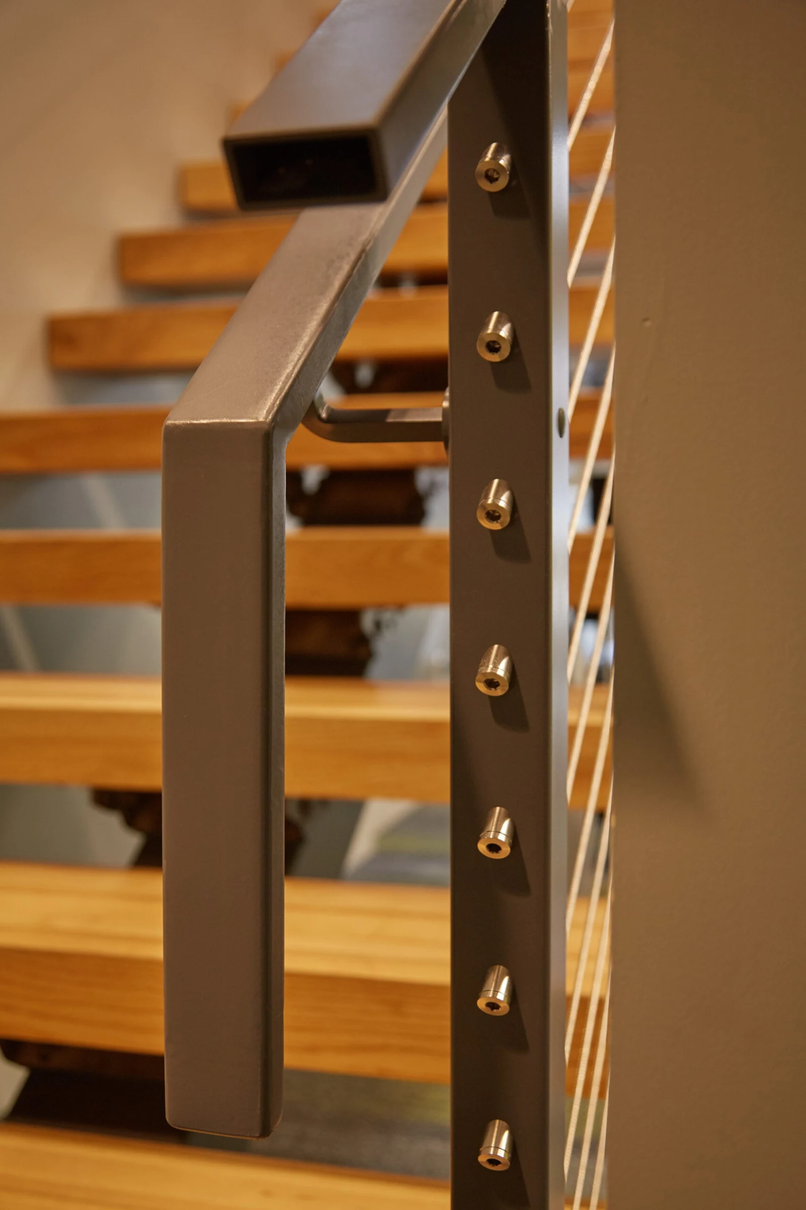 Close view of a square top rail meeting a post with cable ends