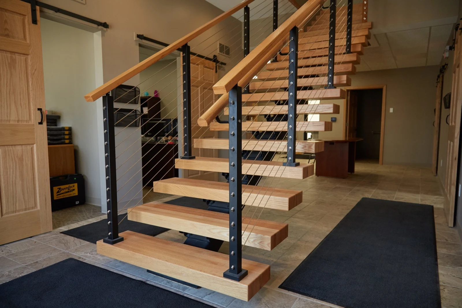 Short flight of thick light treads with cable railing near sliding barn doors