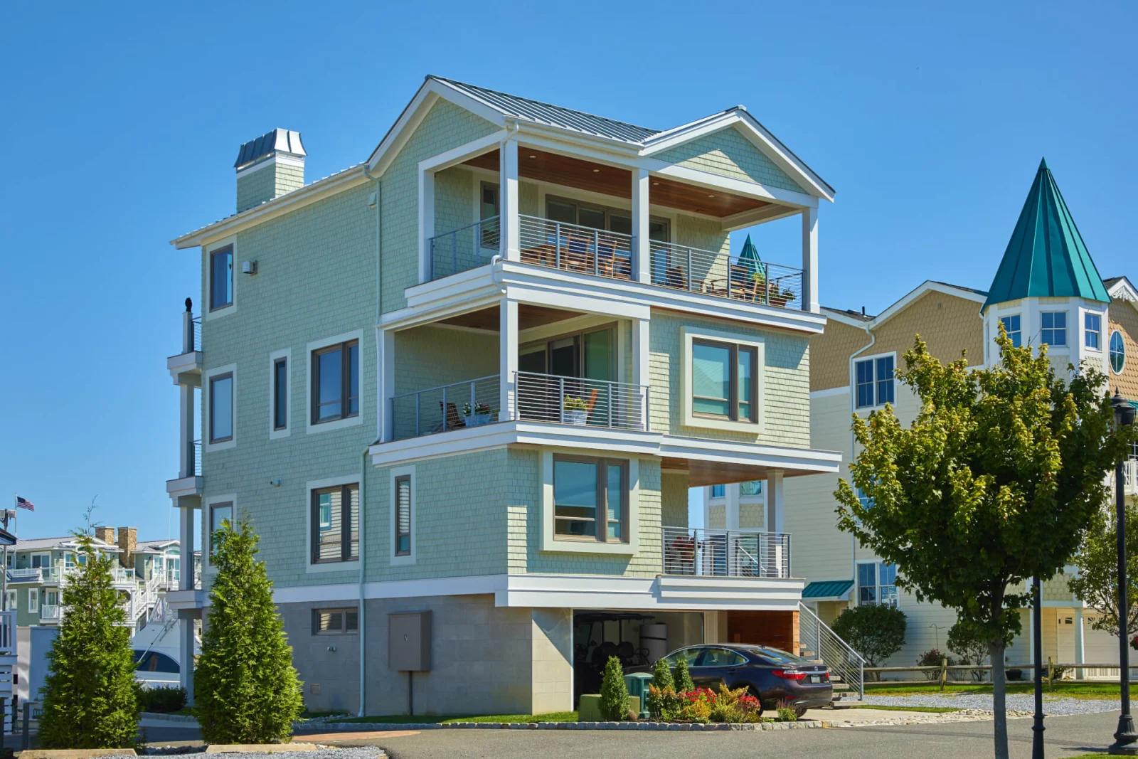 Pale green three-story shore house with railed balconies on every level