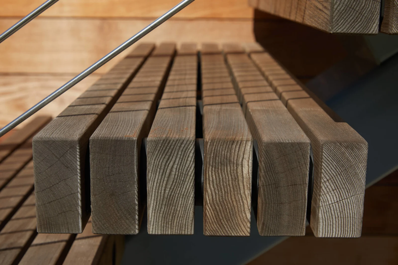 Close view of slatted gray-toned wood tread boards on an outdoor stair