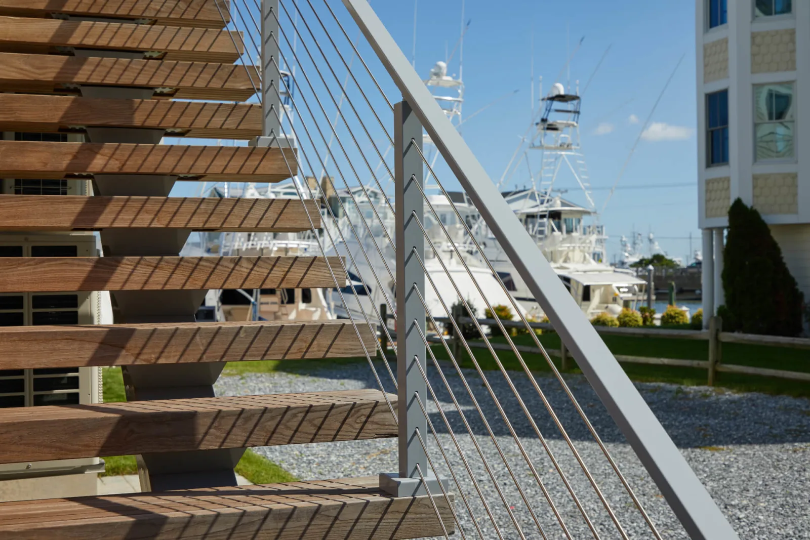 Open slatted treads and stainless rod infill with boats moored beyond