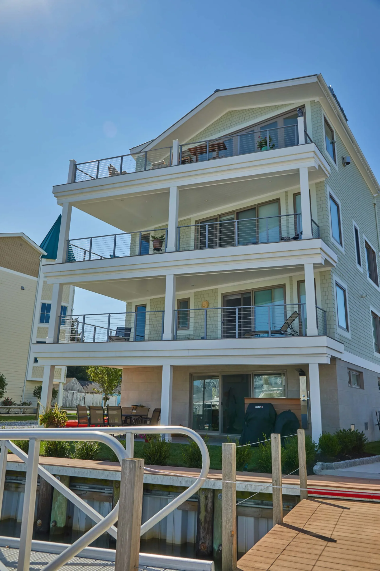 Waterfront elevation of the house with stacked balconies and metal railings