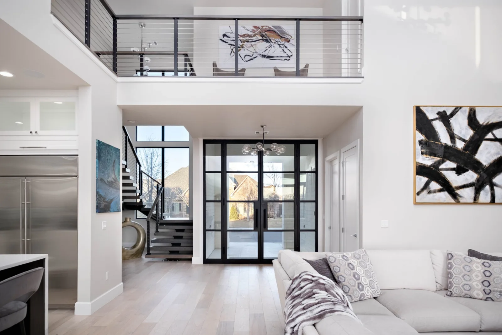 Open great room with a loft balcony rod railing above the seating area