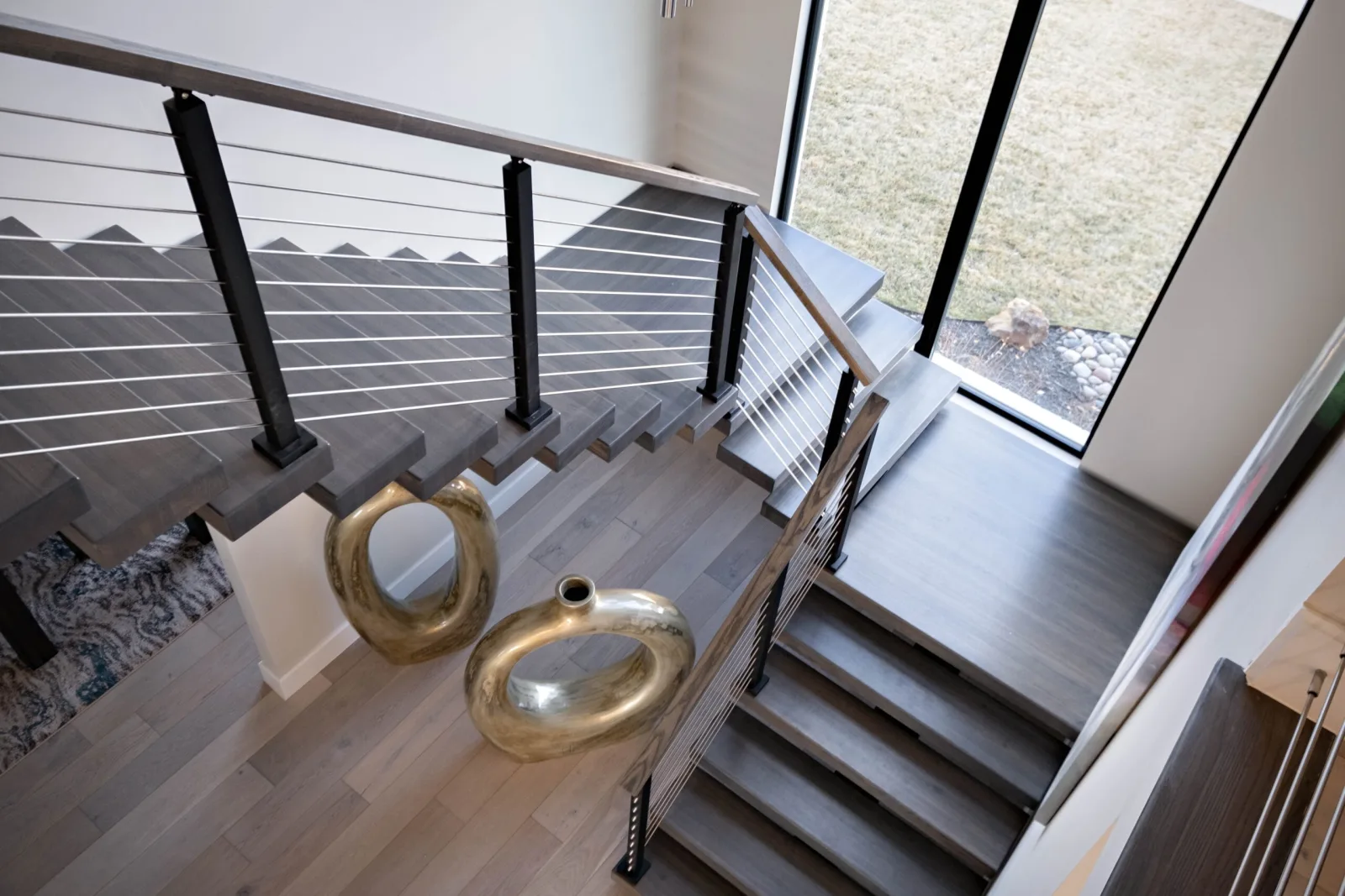 Looking down from the upper level onto the stair and horizontal rod railing