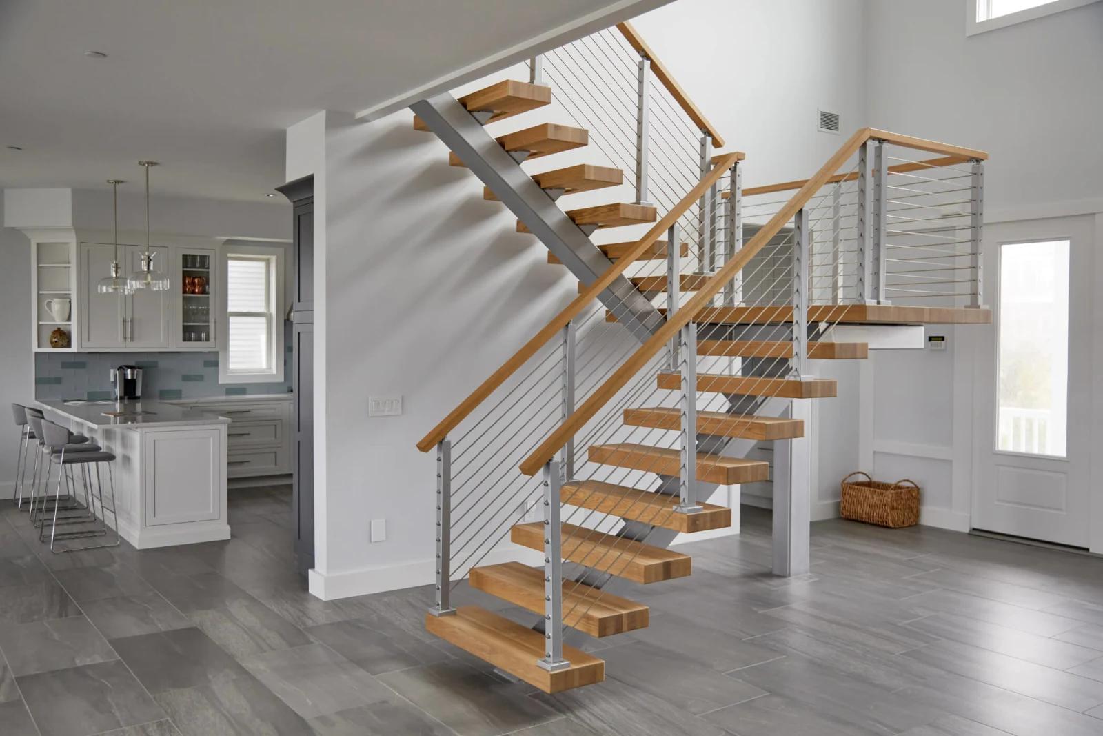 Full run of the stair with the kitchen and entry door in view