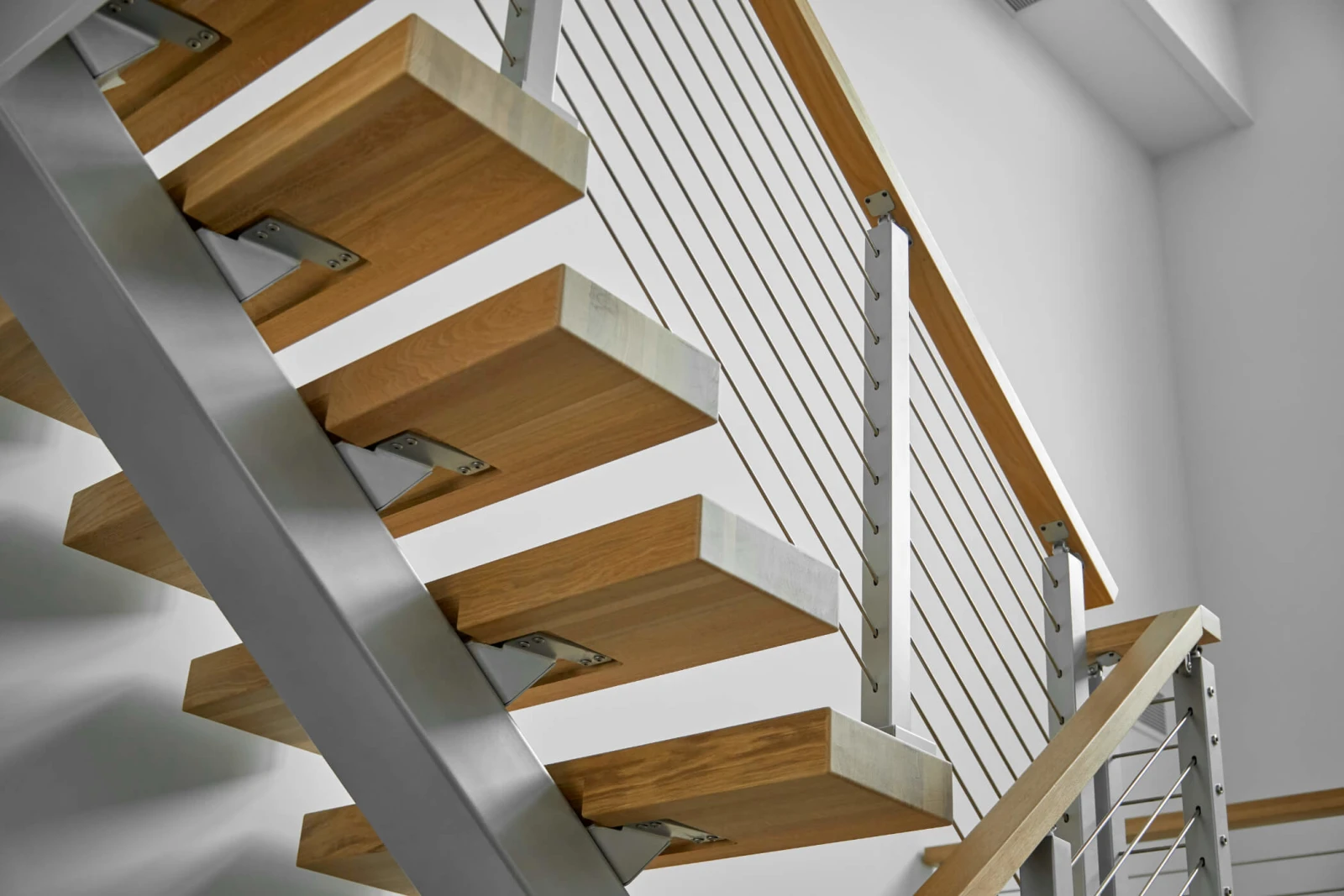 Looking up at cantilevered treads and the gray stringer from below