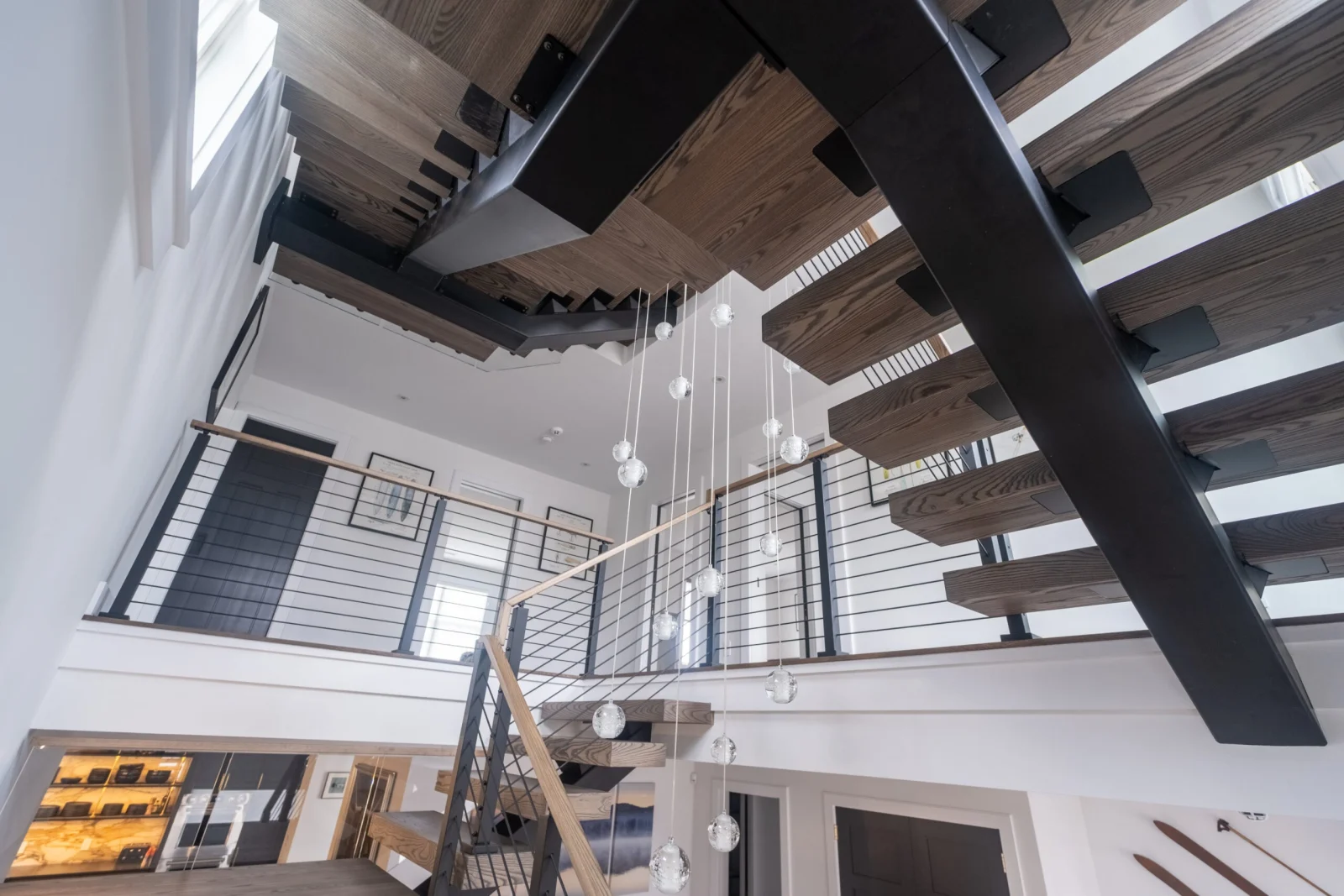 Looking up into the two-story space at the flight and rod railing overlook
