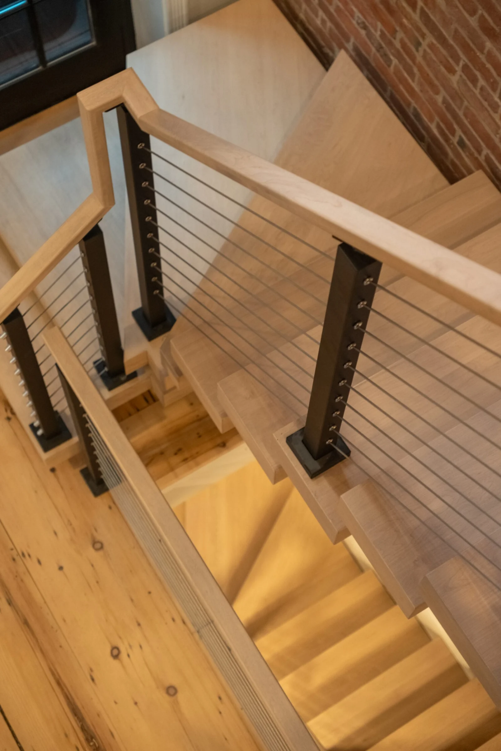 Looking down winder treads with cable railing on both sides