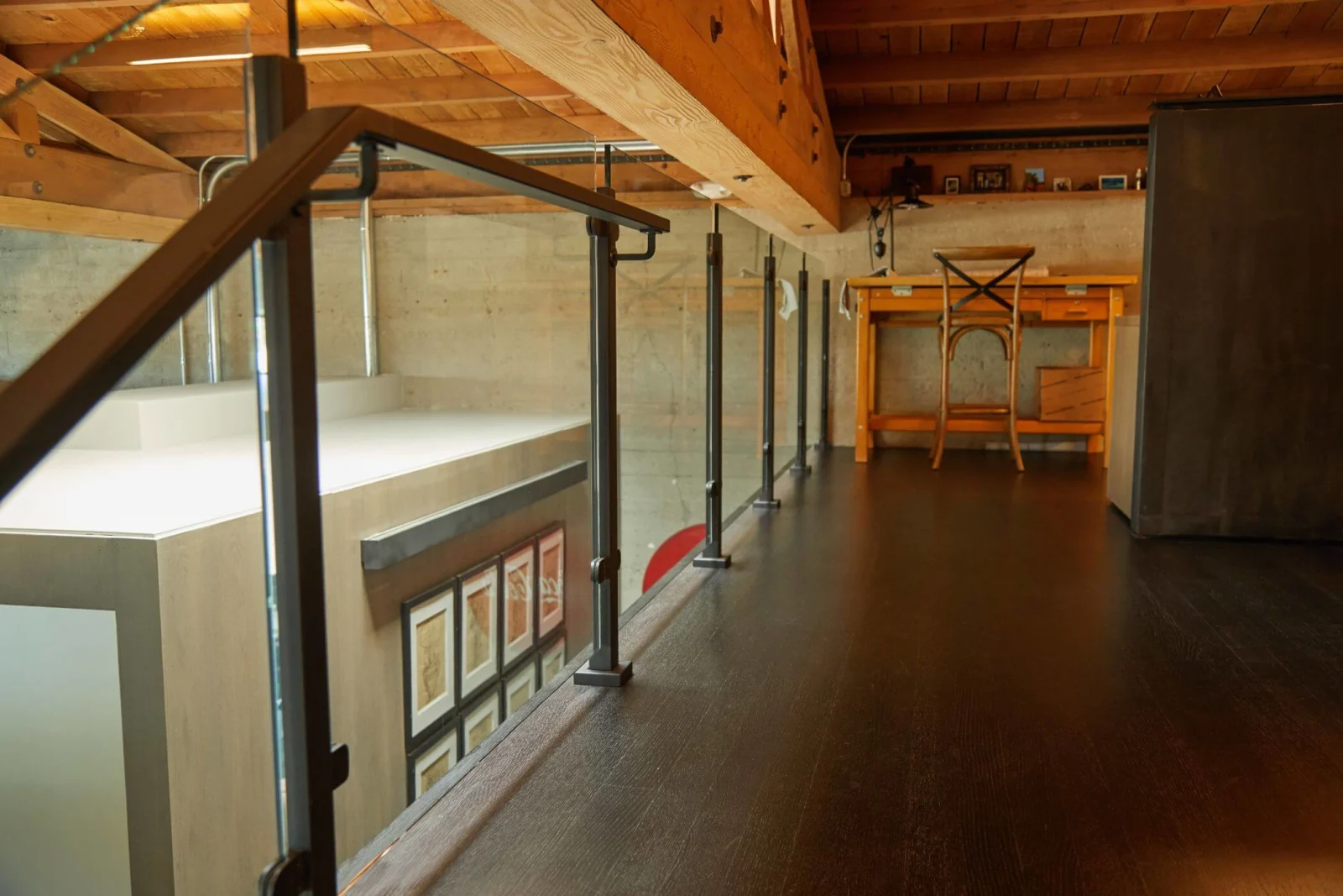 Loft walkway edged with surface-mounted glass railing posts