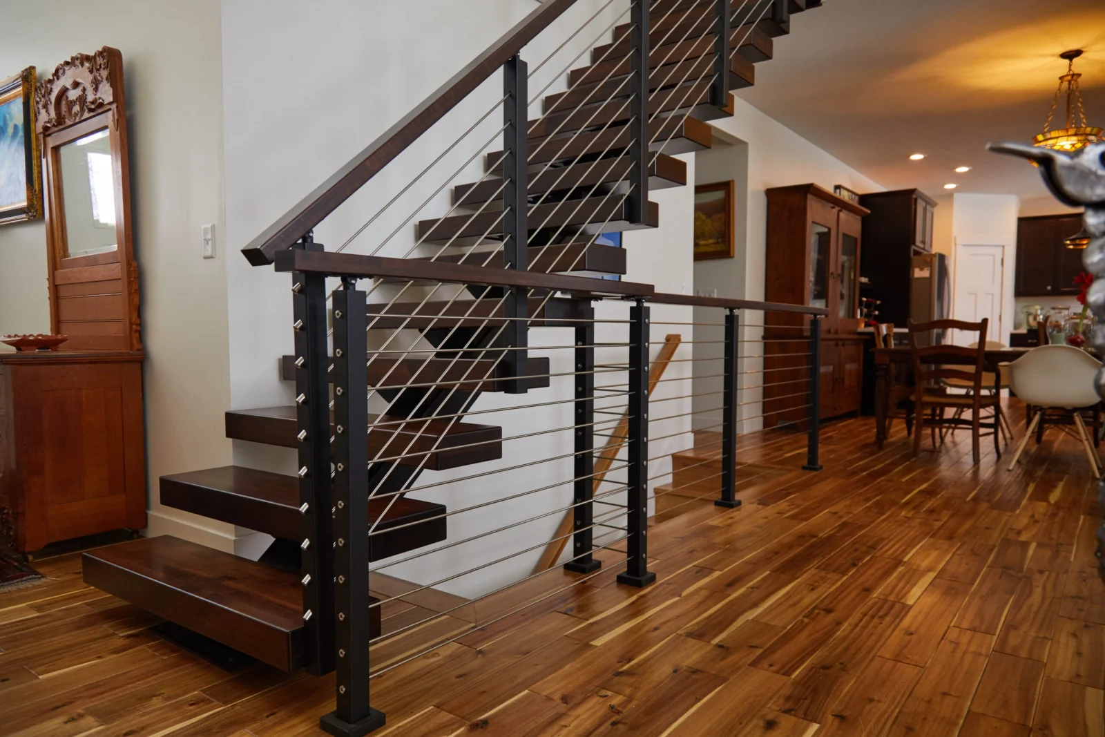 Entry view of the stair and landing railing over wide-plank flooring