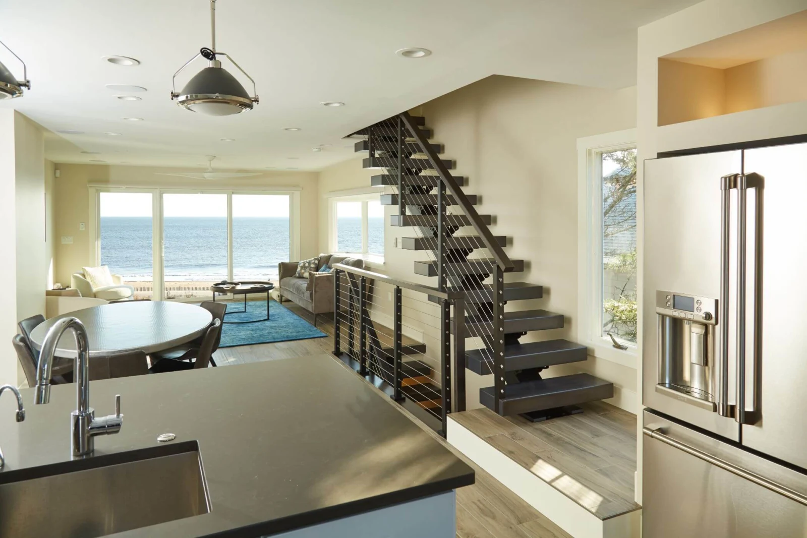Open kitchen and living space with the stair beside an ocean view