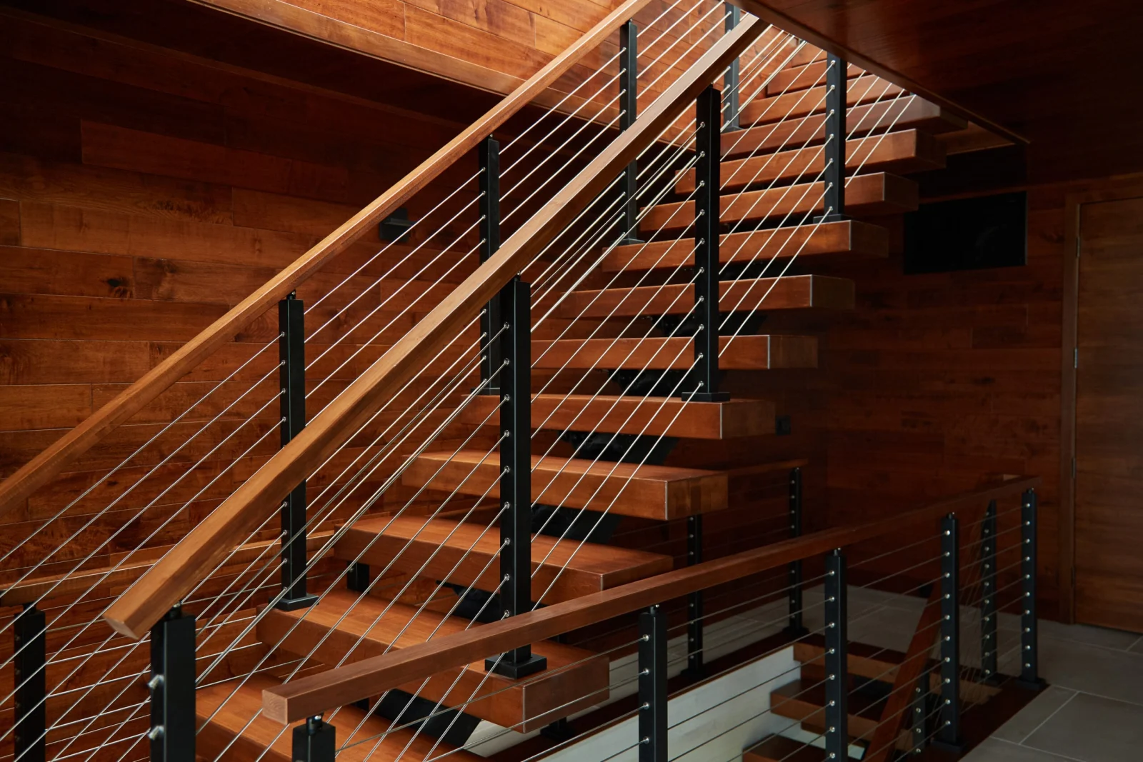 Side view of the flight with black posts against a wood-clad wall