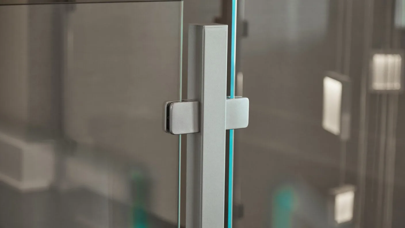 Close view of a brushed metal post clamping a glass panel