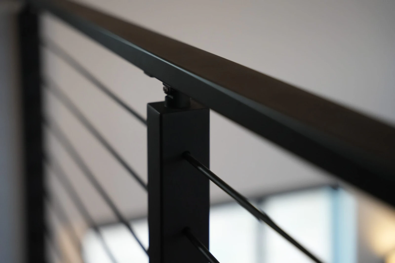 Close view of the top rail seated on a post cap as rods fan downward