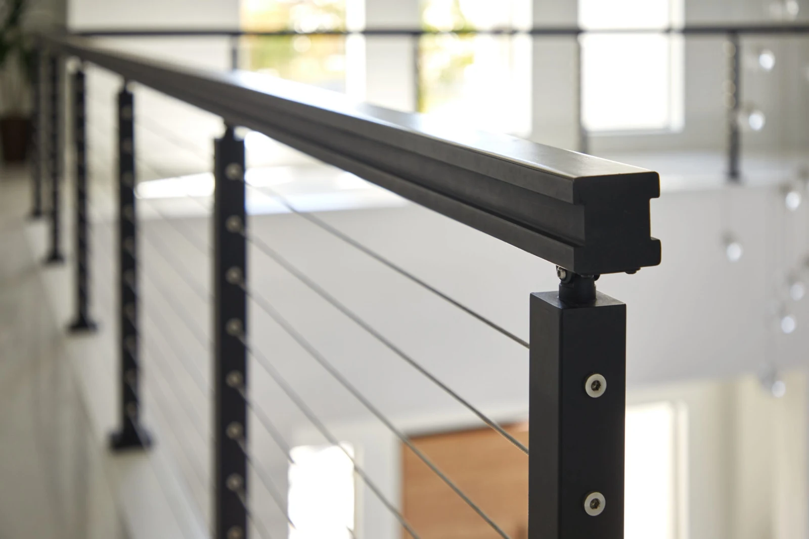Close view of a black top rail and post with swaged cable fittings