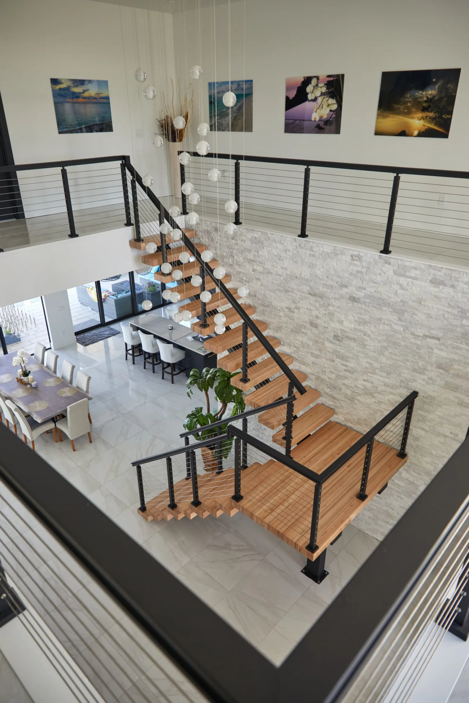 Overhead view from the upper level down the flight to a dining area below