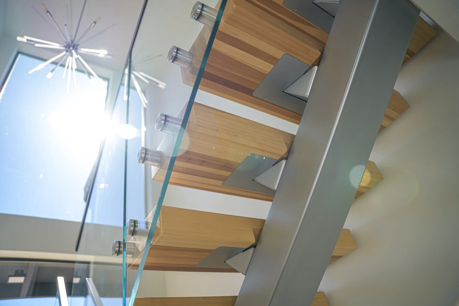 Looking up the underside of the treads and stringer toward a starburst light fixture