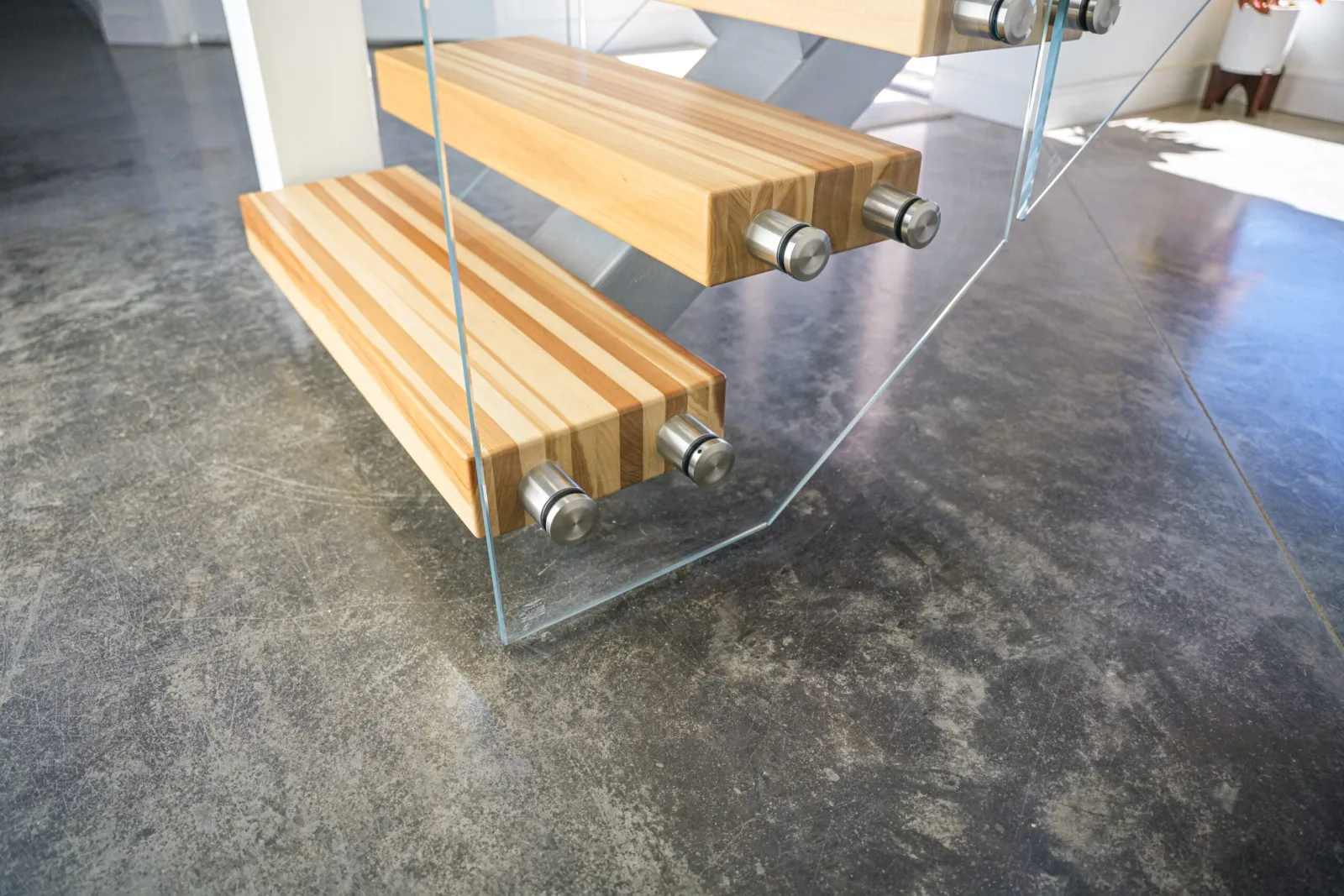 Lowest two treads cantilevered through the glass panel on brushed pin hardware
