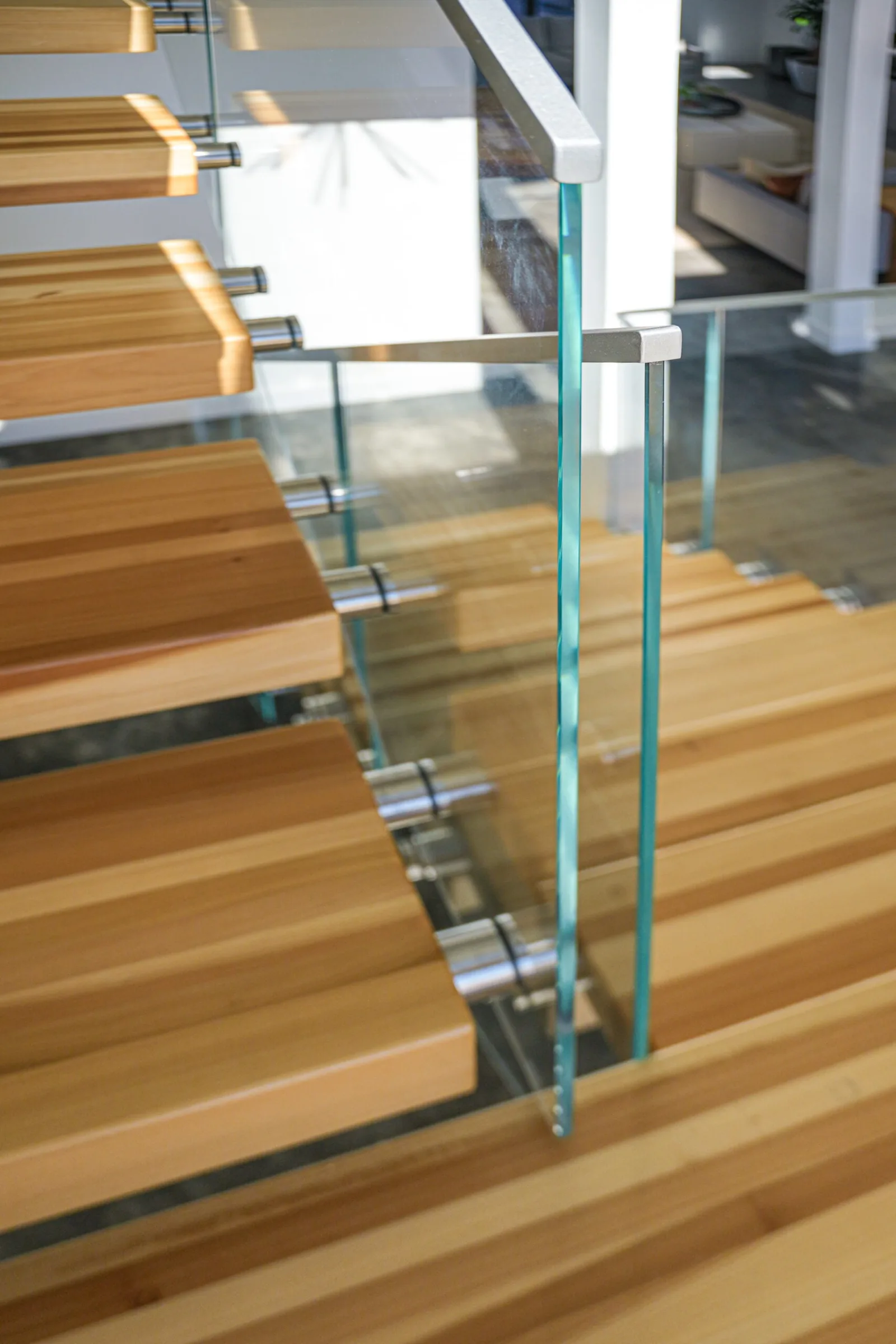 Two glass panels meeting at a corner post above the treads, seen from above