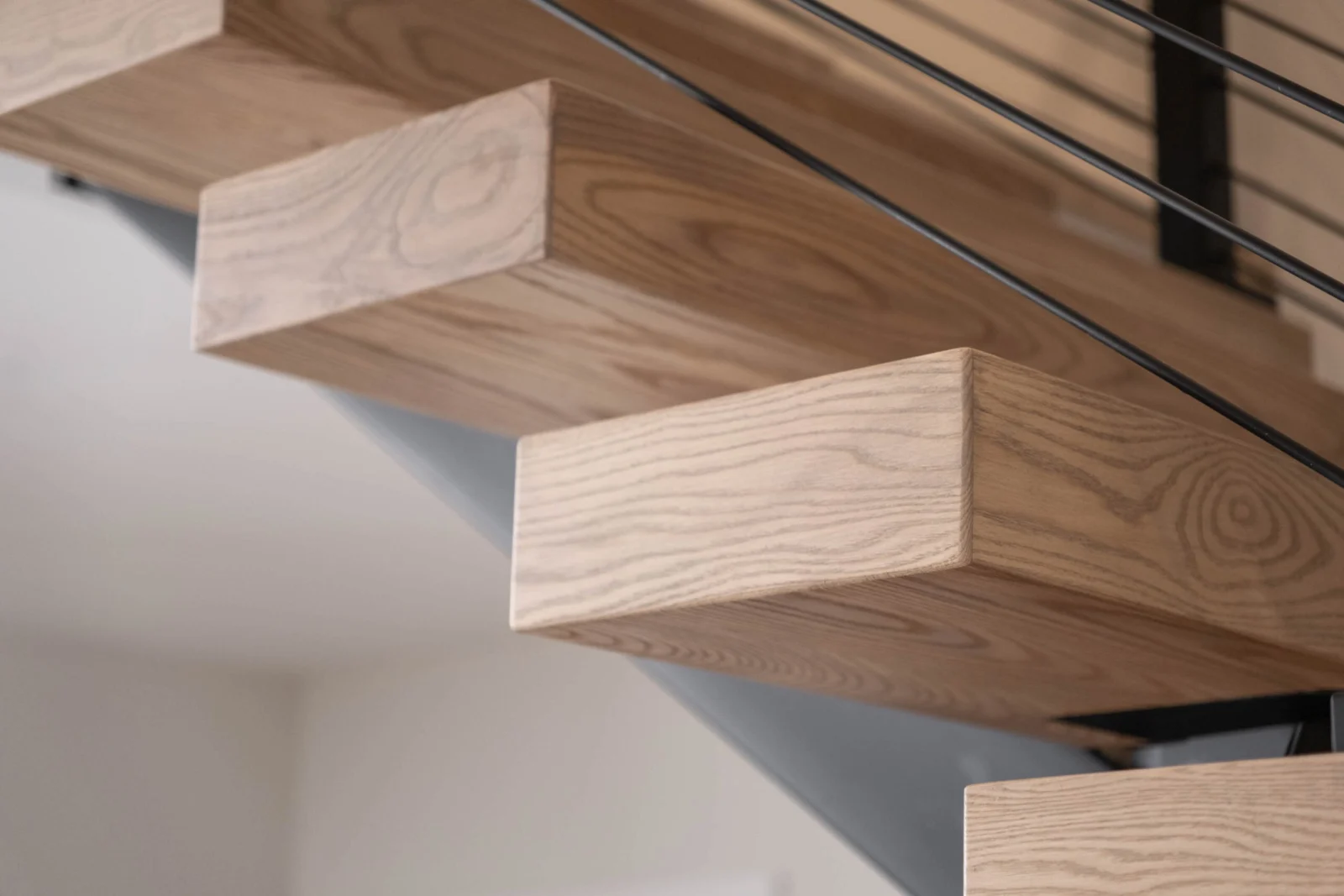 Series of cantilevered treads seen from beneath, each floating clear of the wall