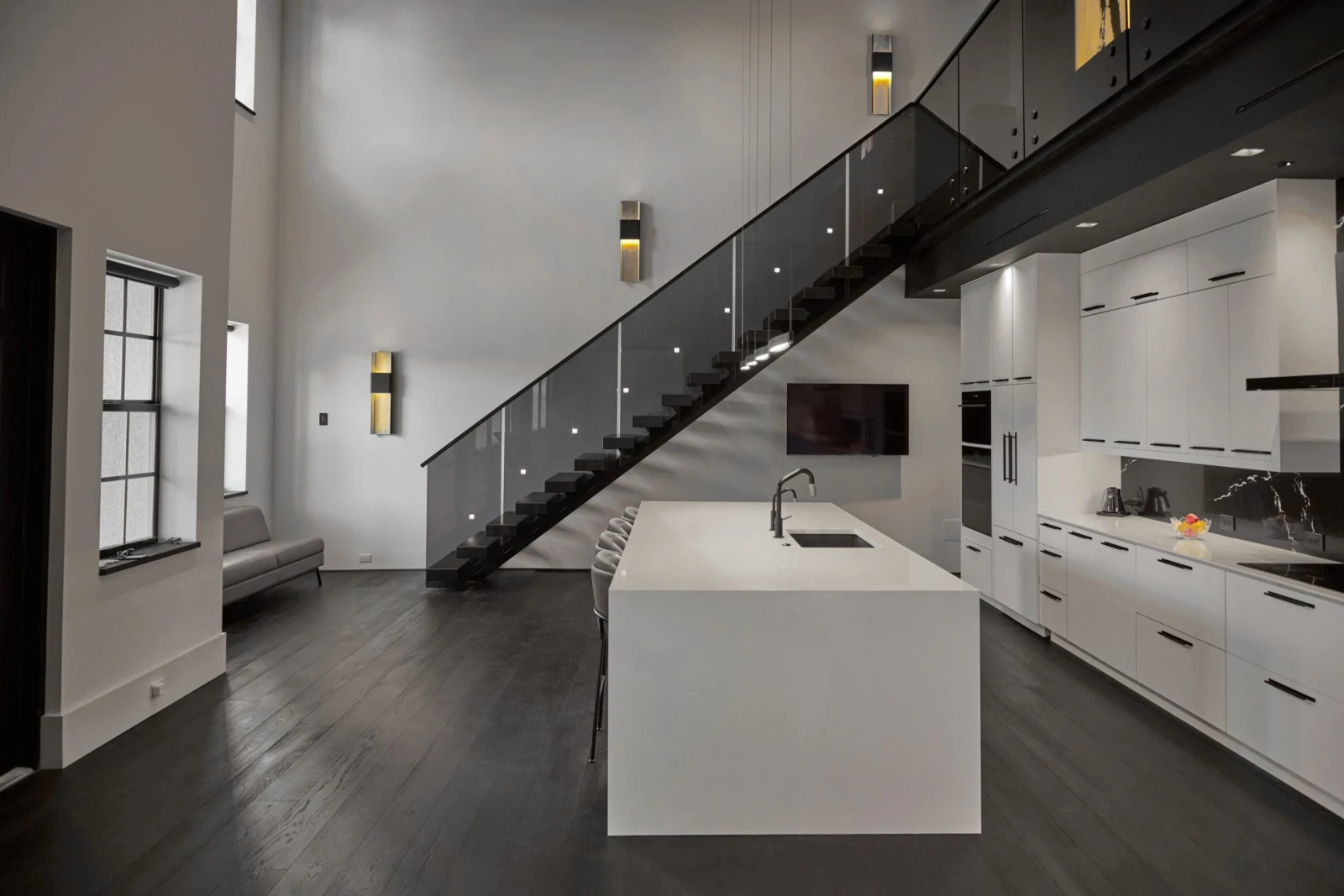 Wide kitchen view with the black stringer and glass railing crossing the wall