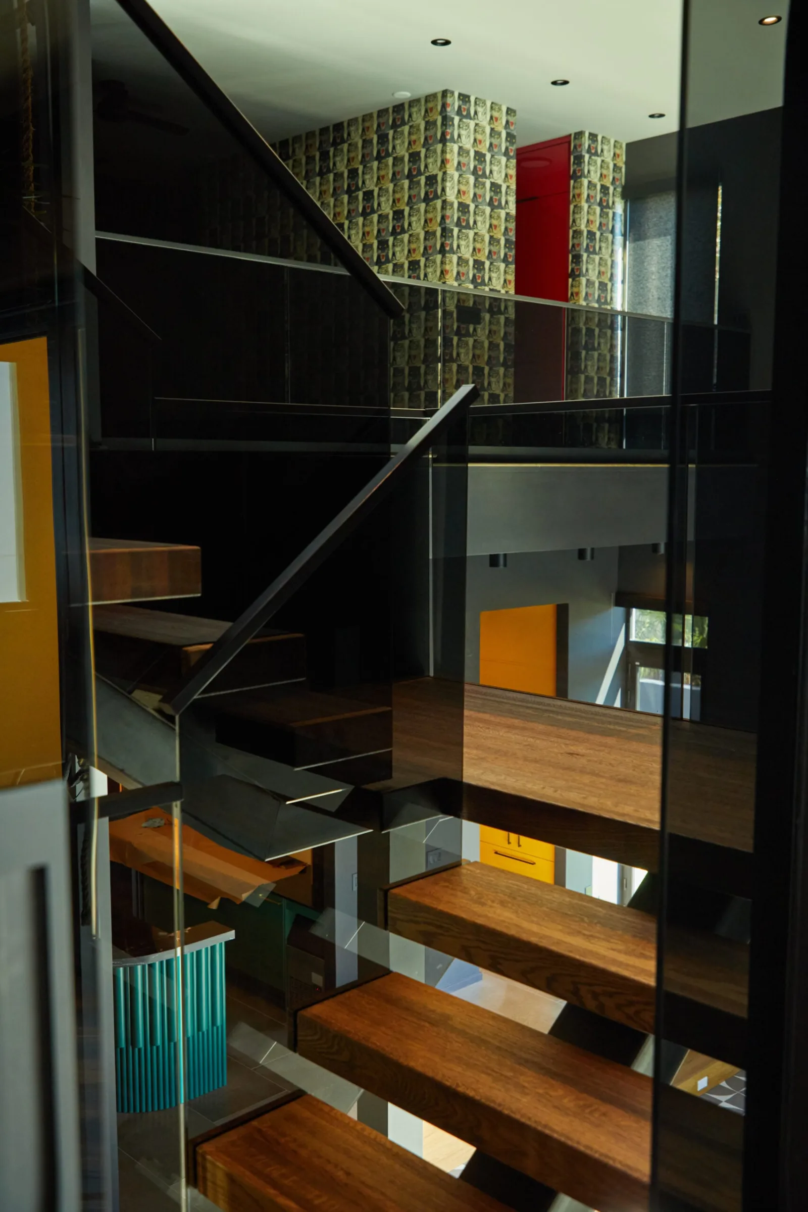 Narrow view up the flight between glass panels toward the upper landing