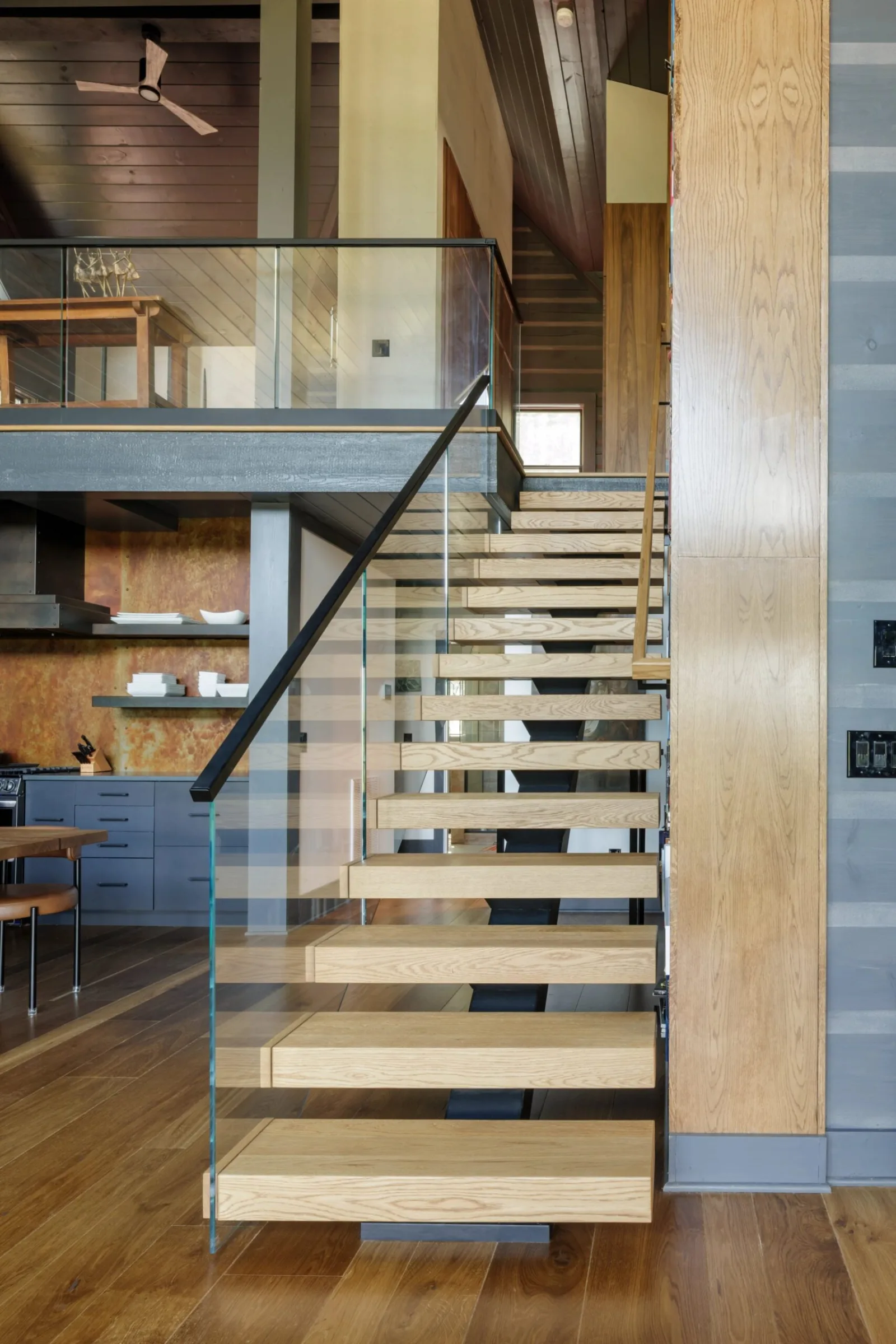 Stair and glass railing seen from the kitchen side of the open room