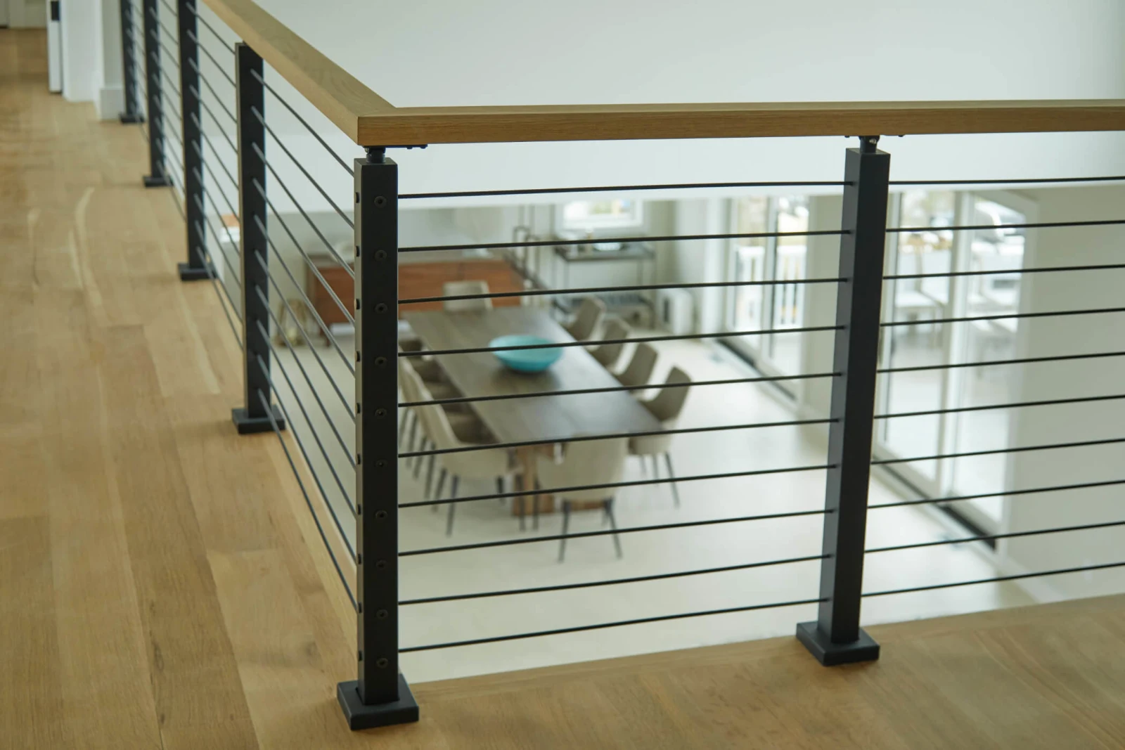 Balcony railing with black posts and rods above the dining room