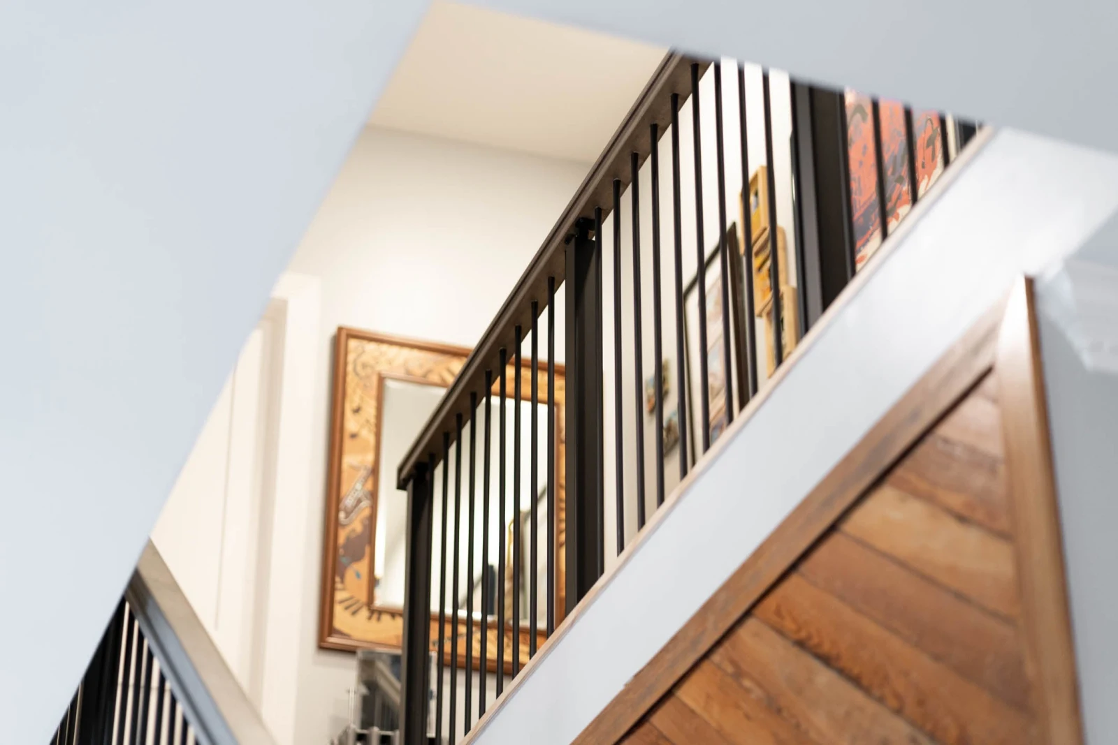 Upward angle at the landing railing with the plank wall at right