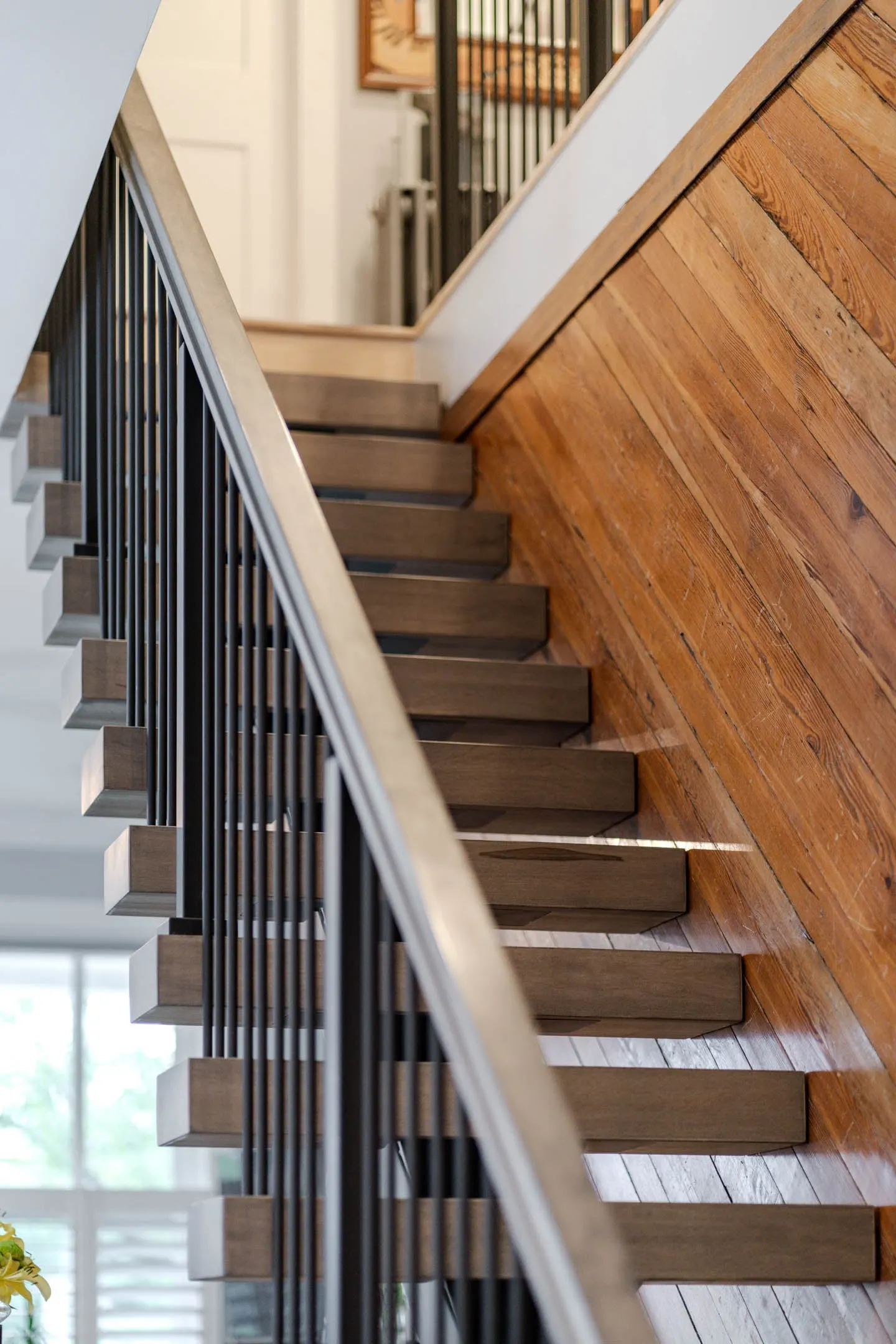 Treads stepping up beside the plank wall behind the rod railing