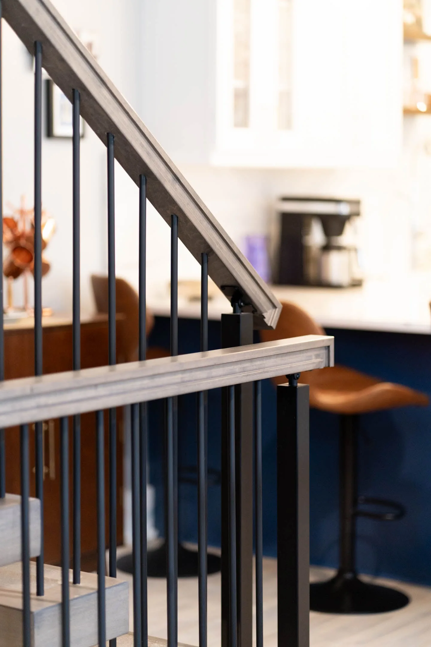 Close detail of vertical rods below a light top rail near the kitchen