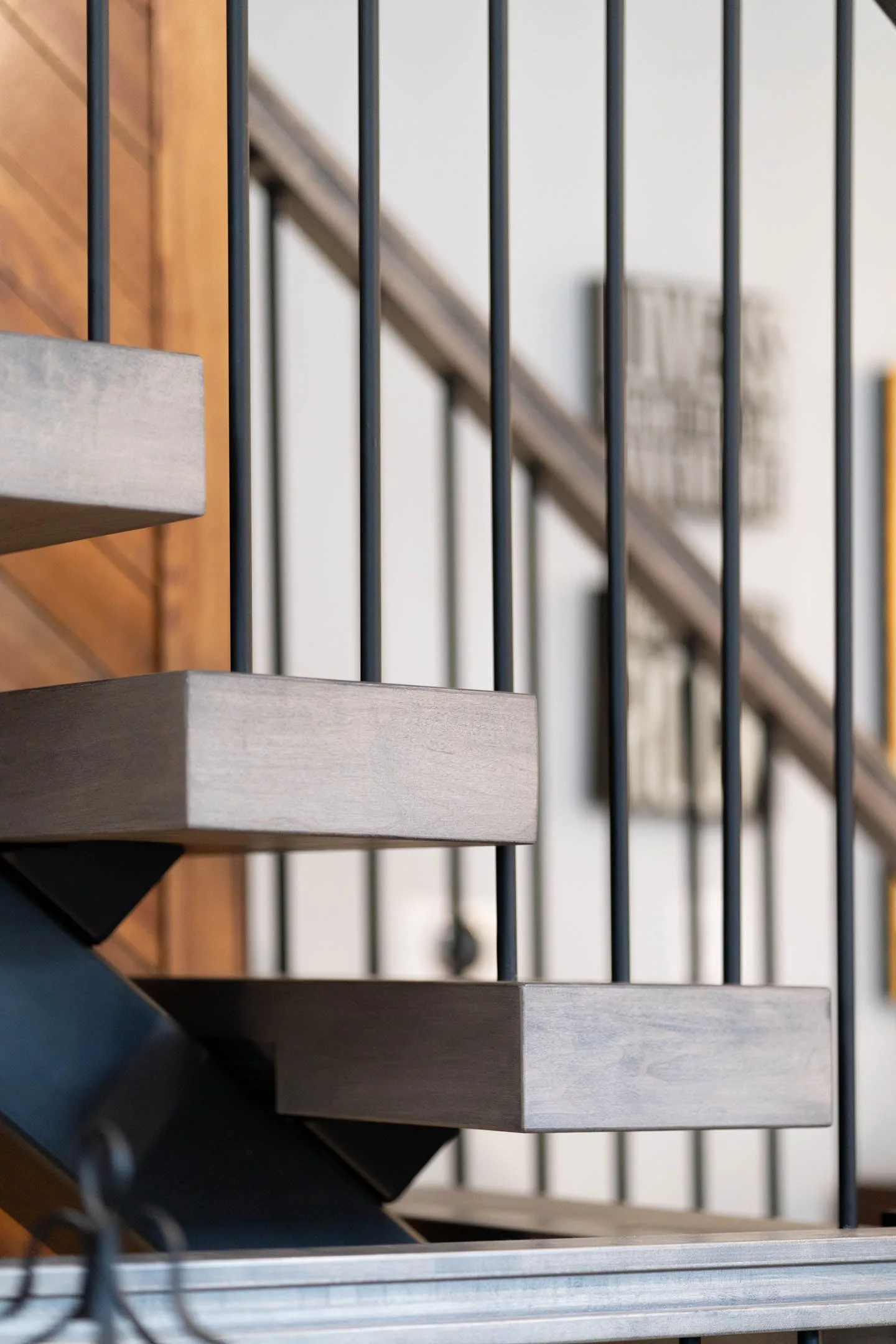 Tread ends beside vertical rods with the wood wall behind