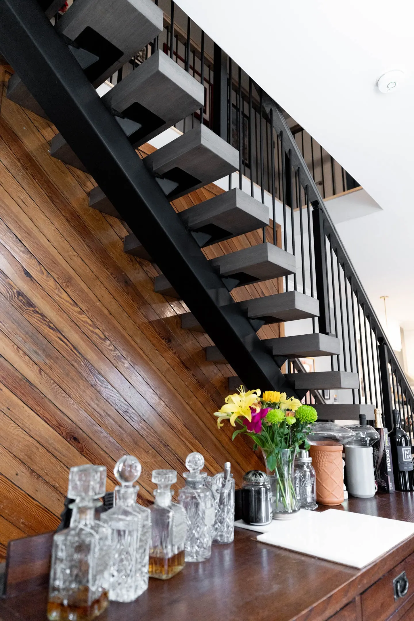 Stair overhead seen from a console table set with decanters and flowers