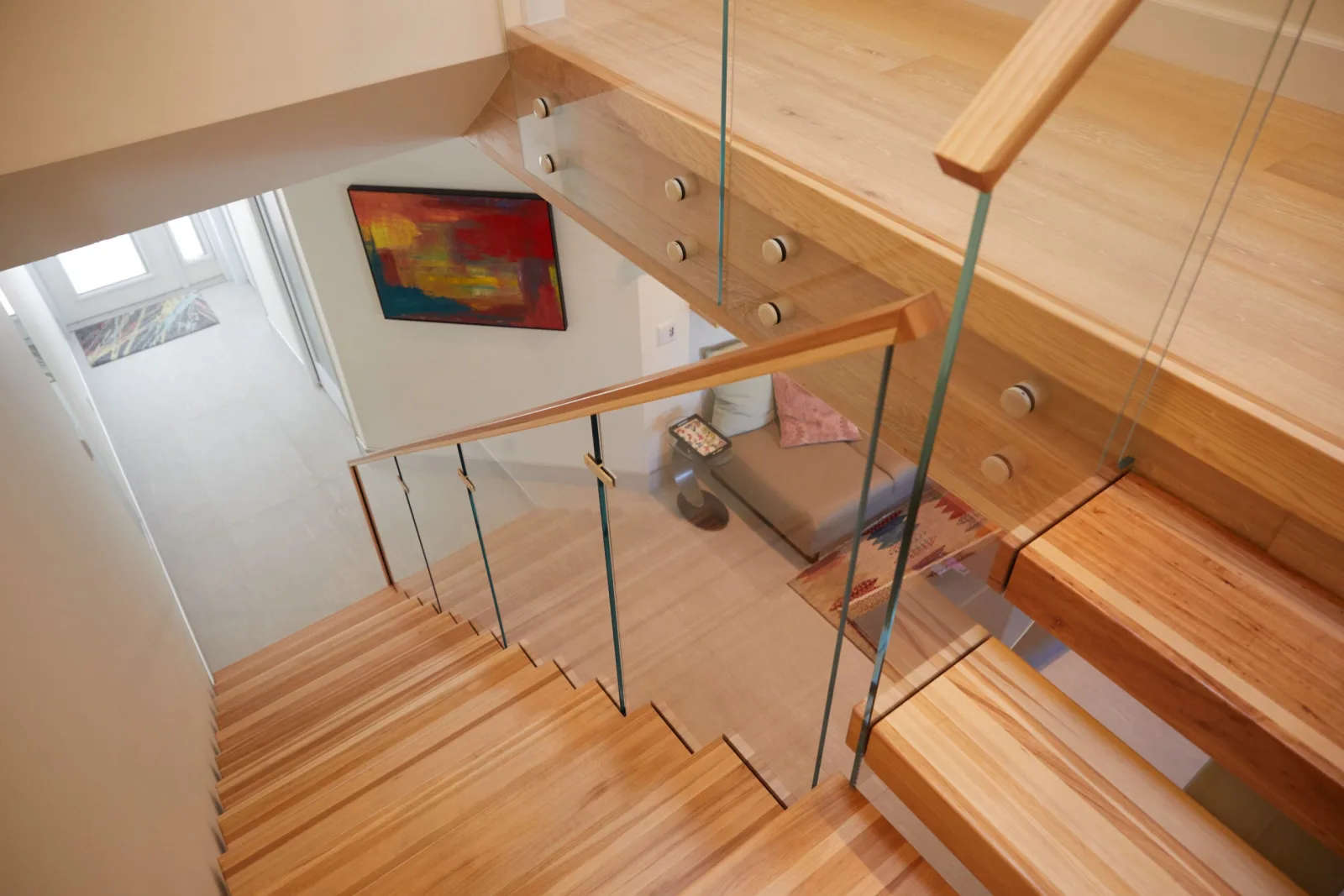 Looking down the stair over glass panels pinned to a wood fascia