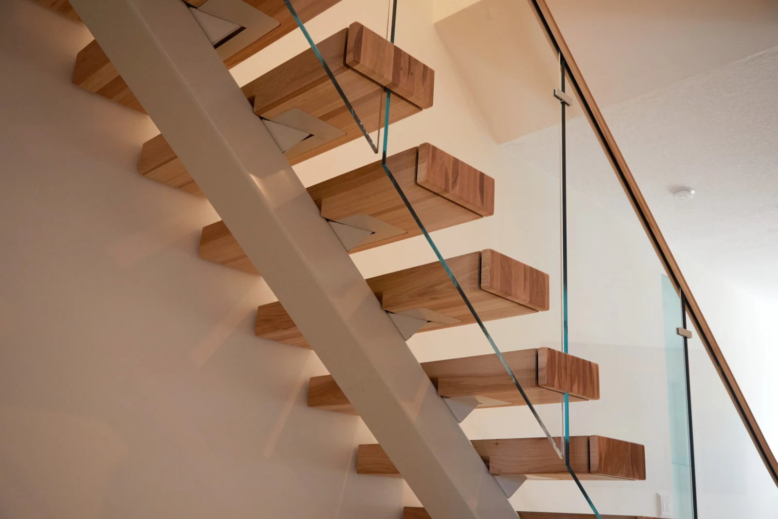Underside view of cantilevered treads bracketed to the painted center stringer