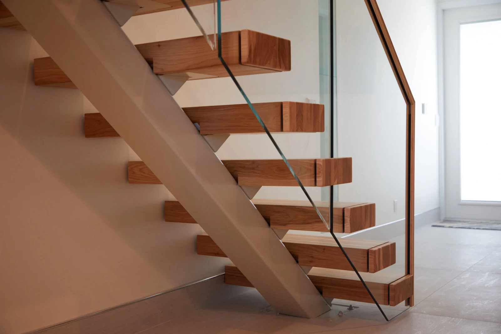 Closer side view of the treads and glass panels along the run