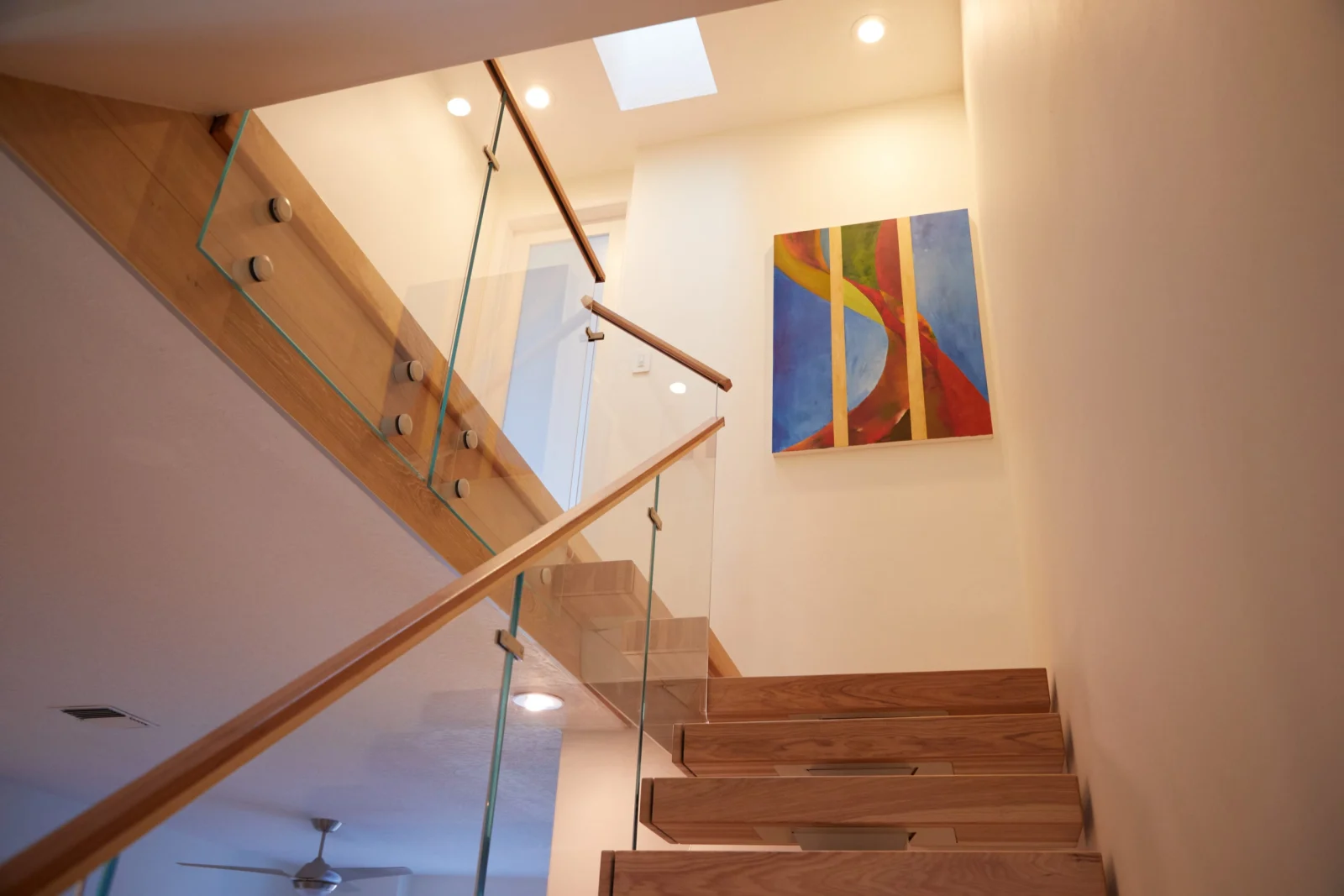 View up the flight with a glass-railed landing and artwork above